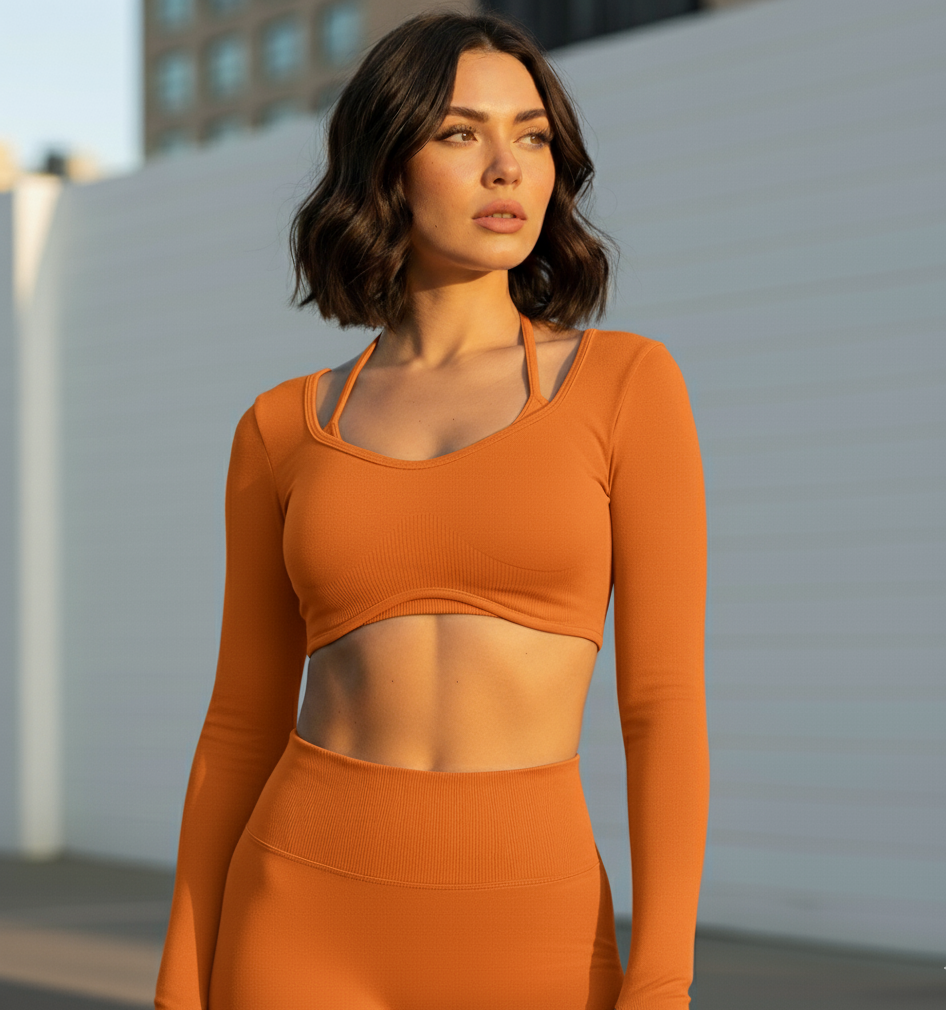 Woman wearing an orange athletic outfit standing outdoors.