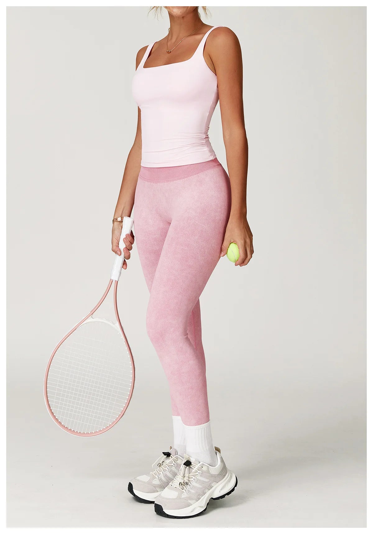 Xooie Fit acid wash leggings for women in pink worn by model holding tennis racket