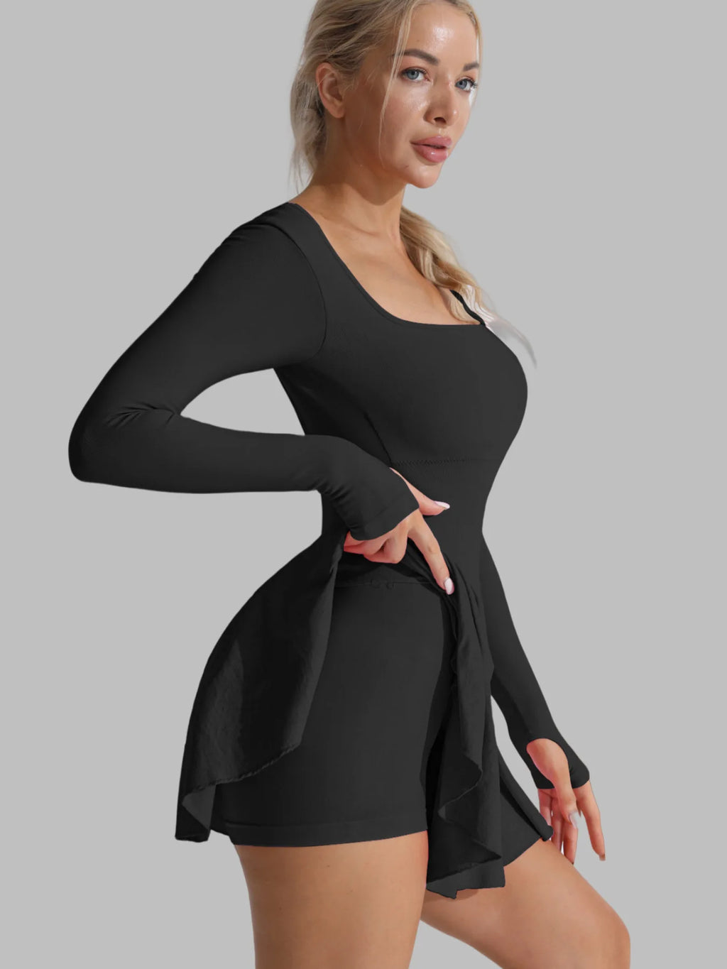 Black long-sleeve active dress with flared skater skirt and built-in shorts; side view.