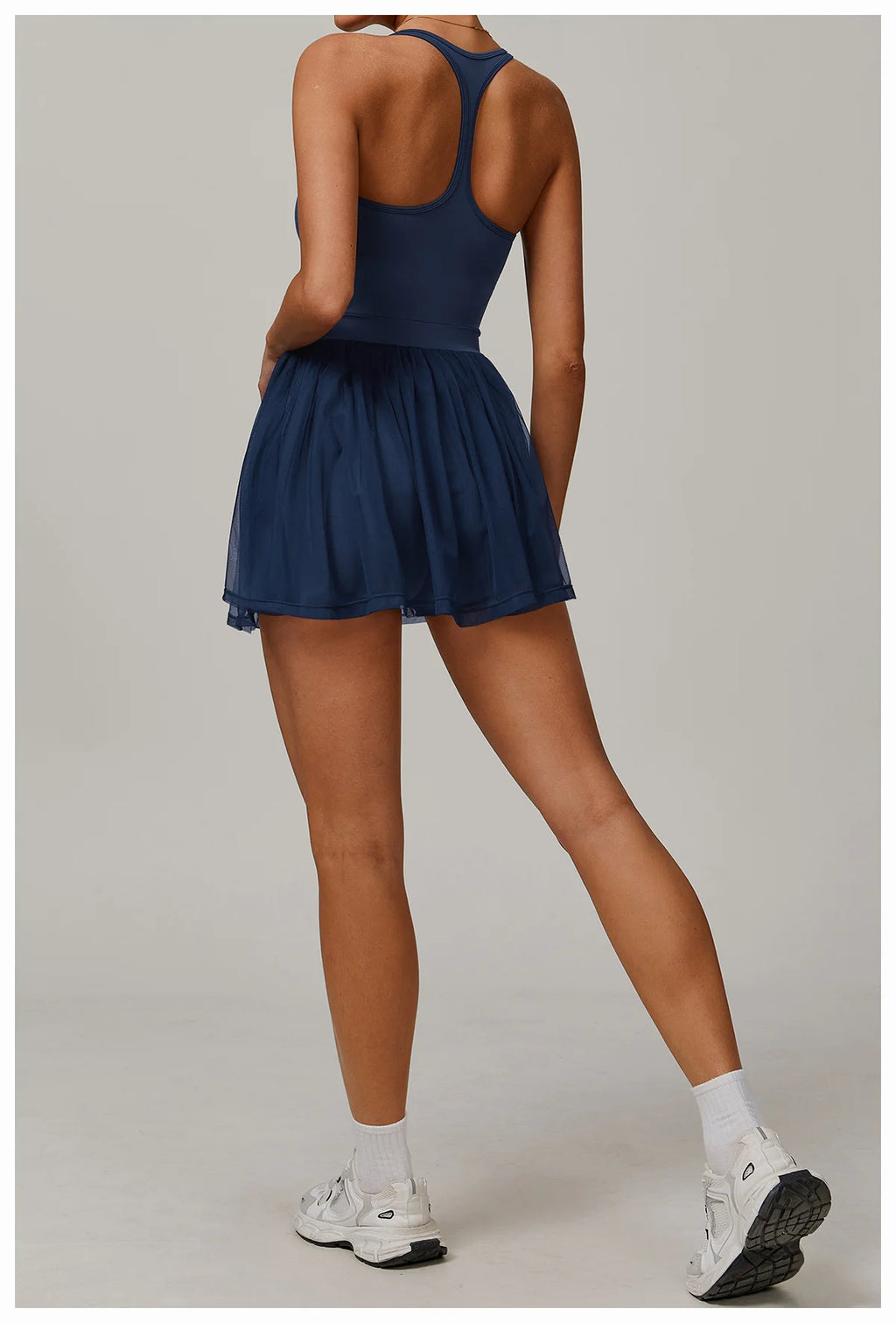 Navy blue back view active dress with racerback and pleated sheer mini skirt