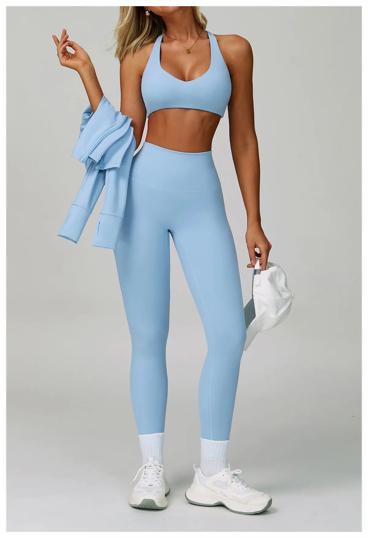 Crystal blue: Sport-BH und High-Waist-Leggings im Ganzkörperbild, mit Sneakern