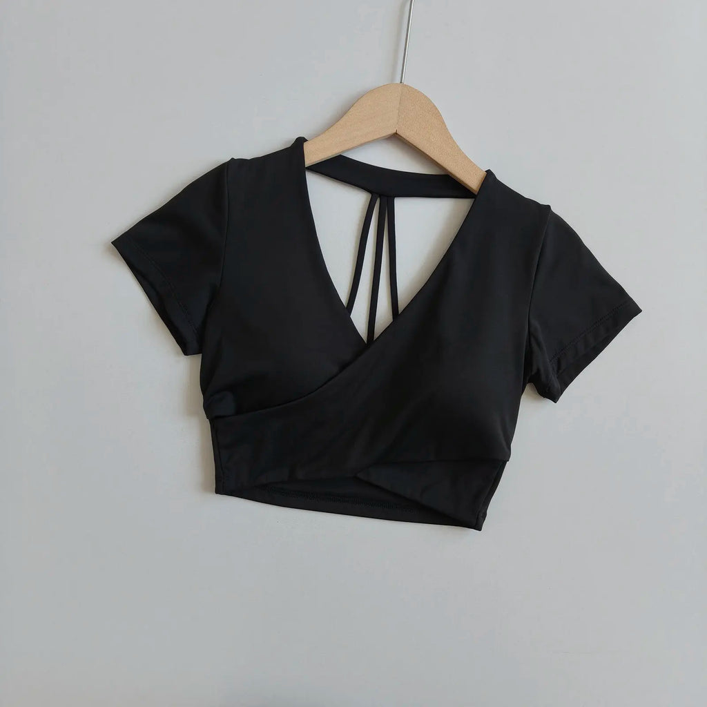 Black short-sleeve cross-over crop top with deep V neckline and crisscross open back