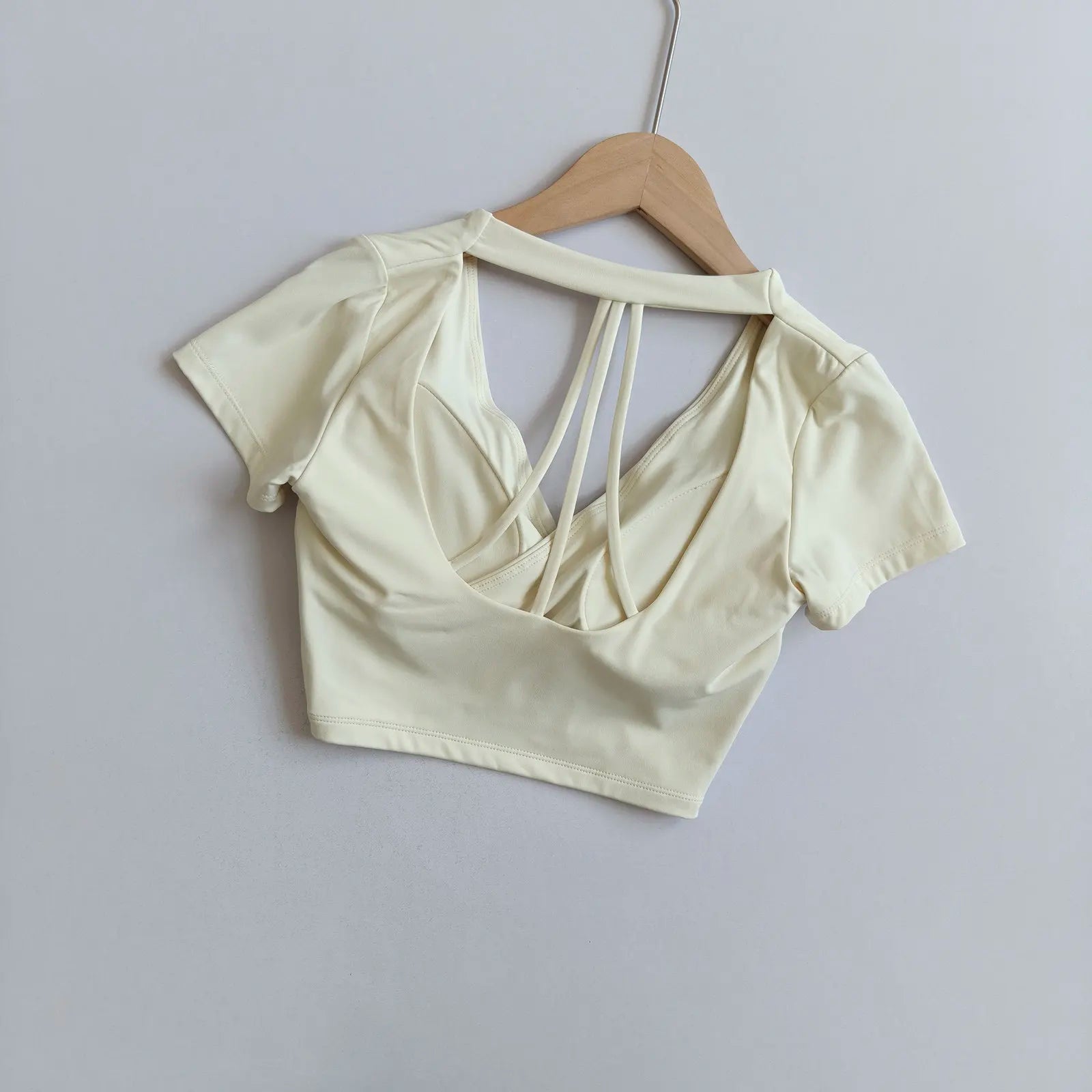Light white short-sleeve crop top with wrap front and crisscross open back straps