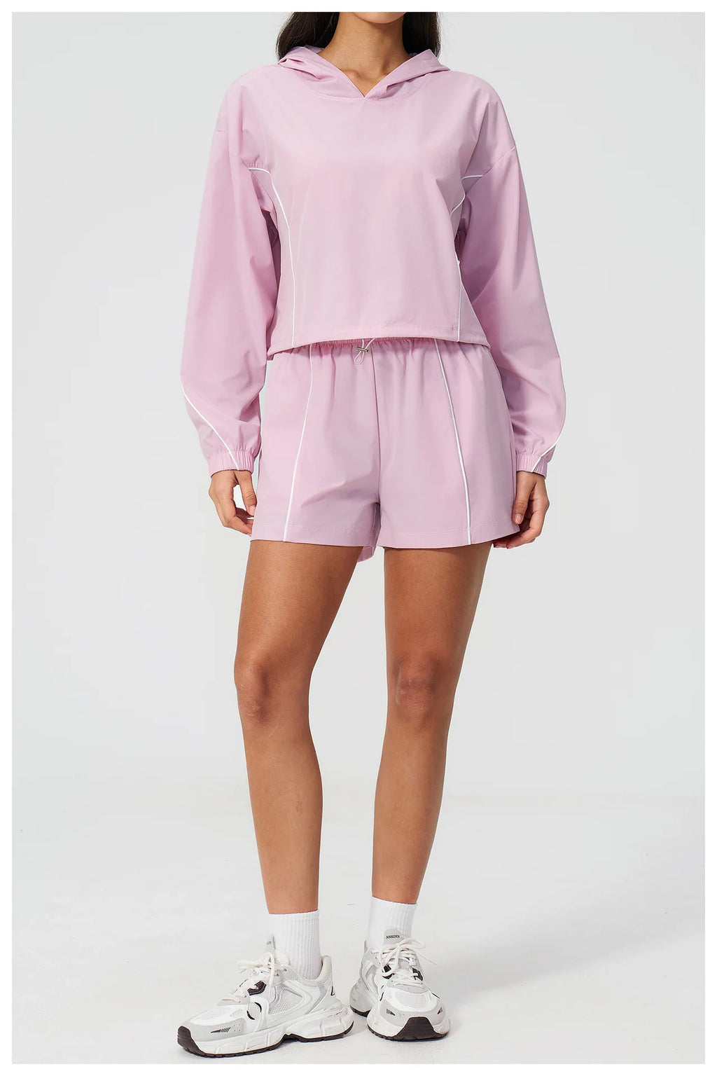 Pink hooded windbreaker top with matching athletic shorts set, long sleeves, elastic waist