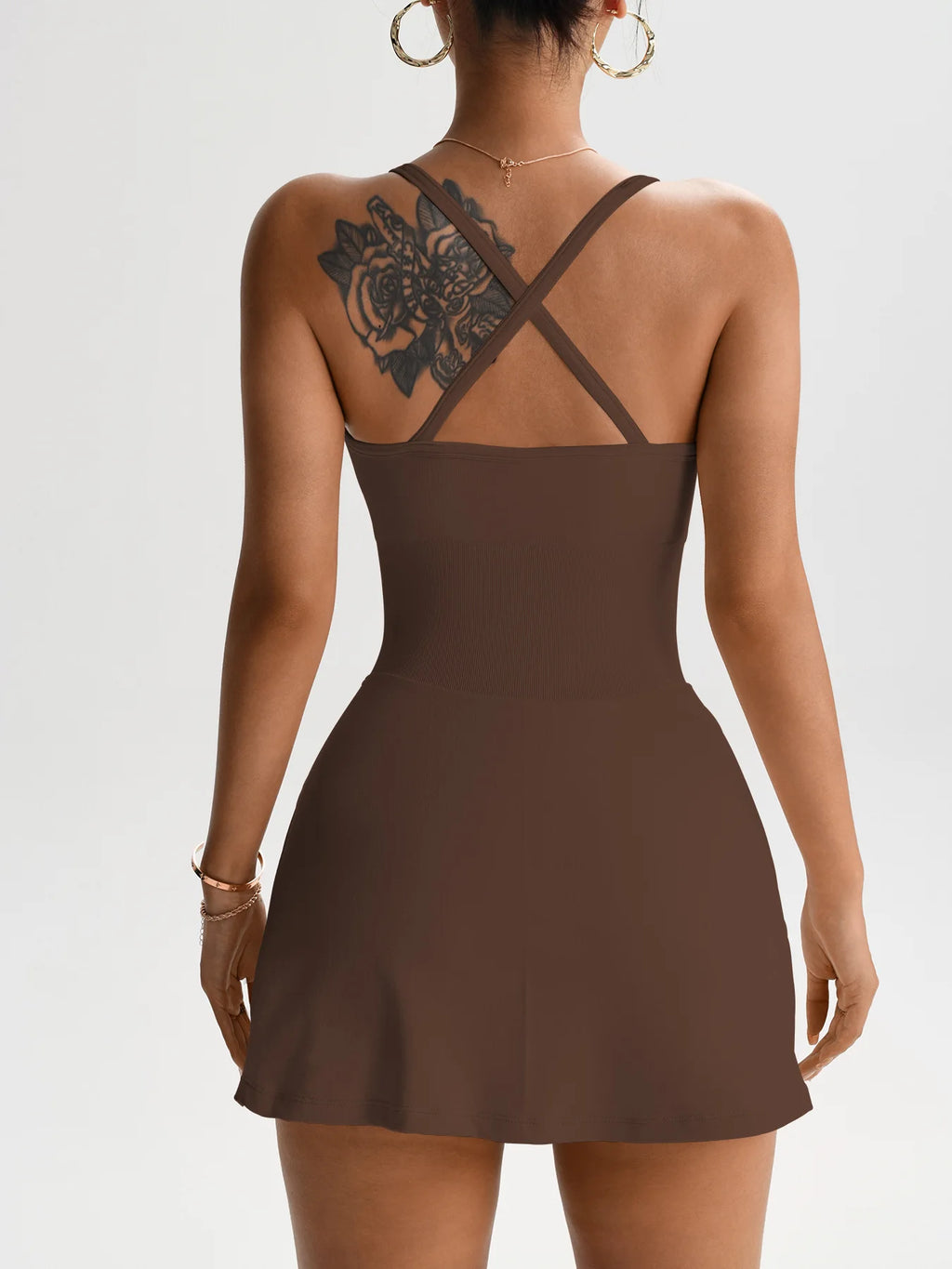 Brown one-piece tennis skort dress shown from back with crisscross straps and open cutout