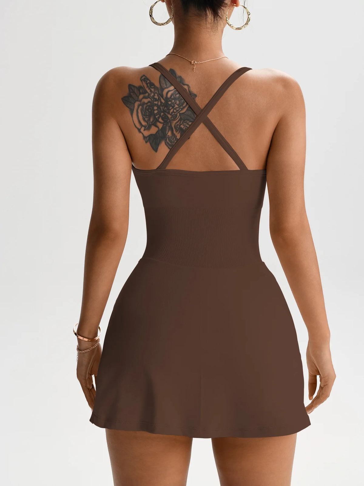 Brown one-piece tennis skort dress shown from back with crisscross straps and open cutout