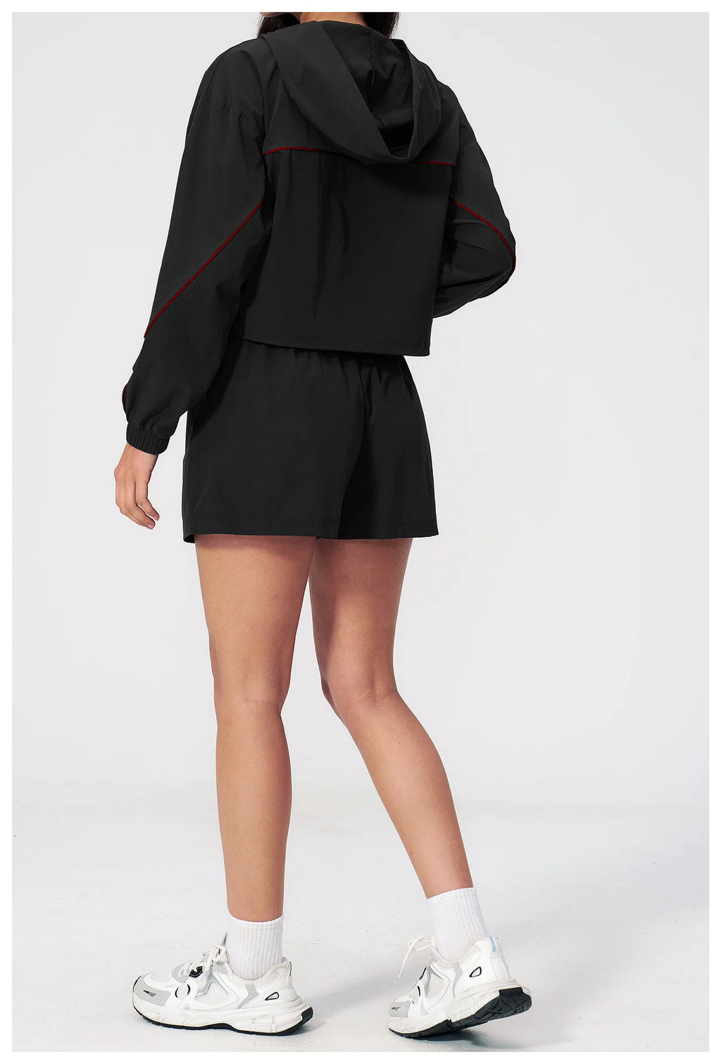 Women’s hooded sports set in black, back view jacket and shorts with red trim
