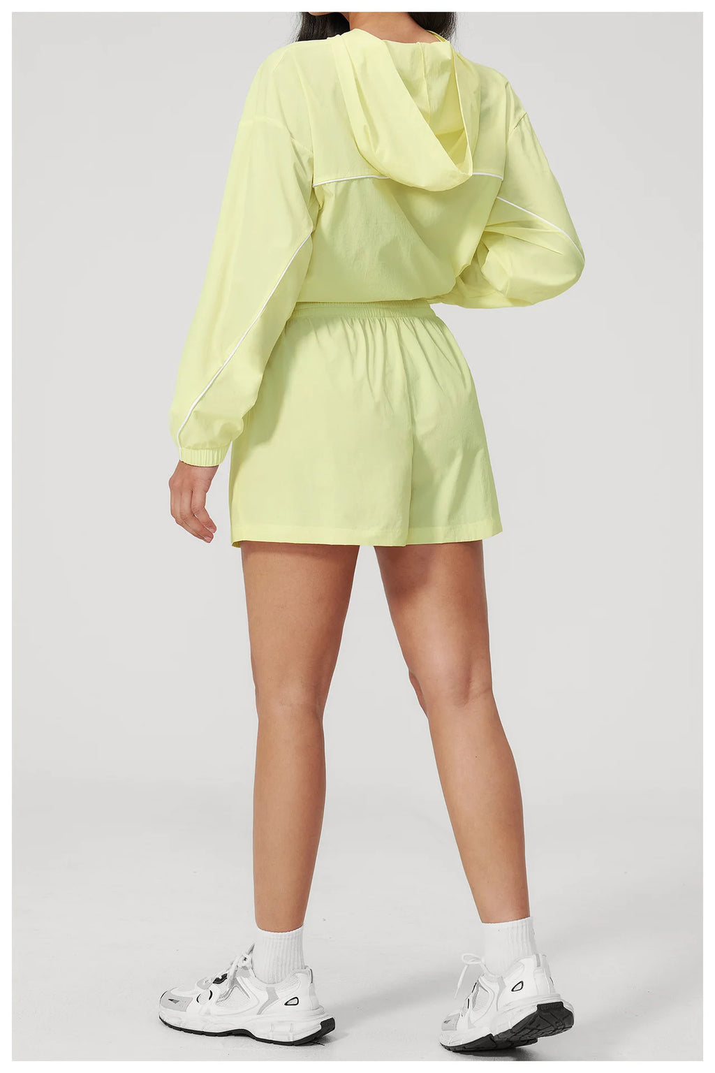 Women’s hooded sports set in light yellow, cropped jacket with hood and matching shorts