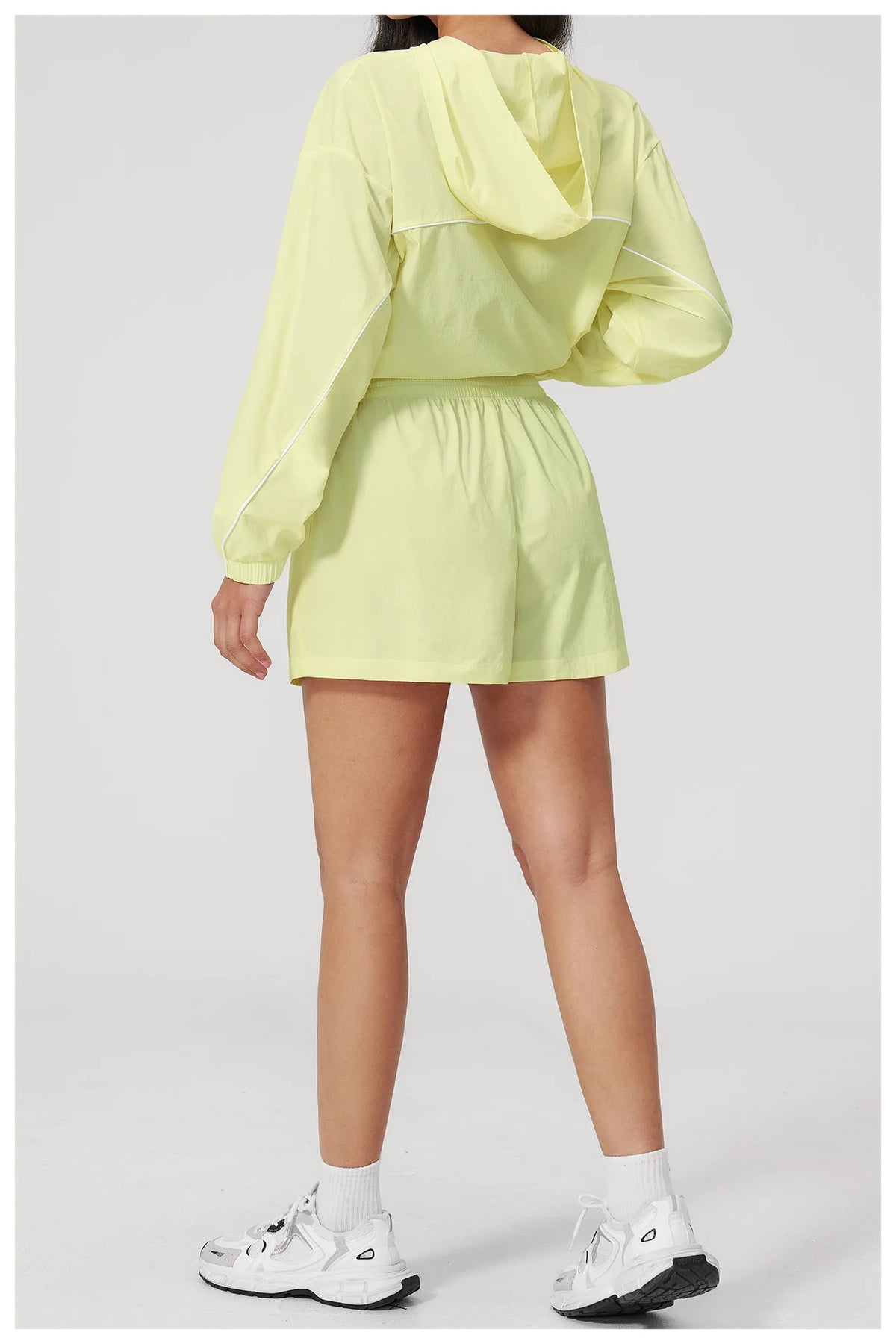 Women’s hooded sports set in light yellow, cropped jacket with hood and matching shorts