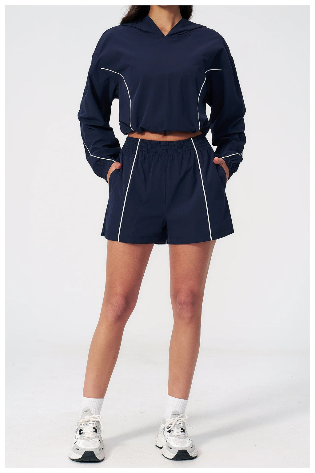 Women’s hooded windbreaker set in navy, front view with cropped jacket and matching shorts