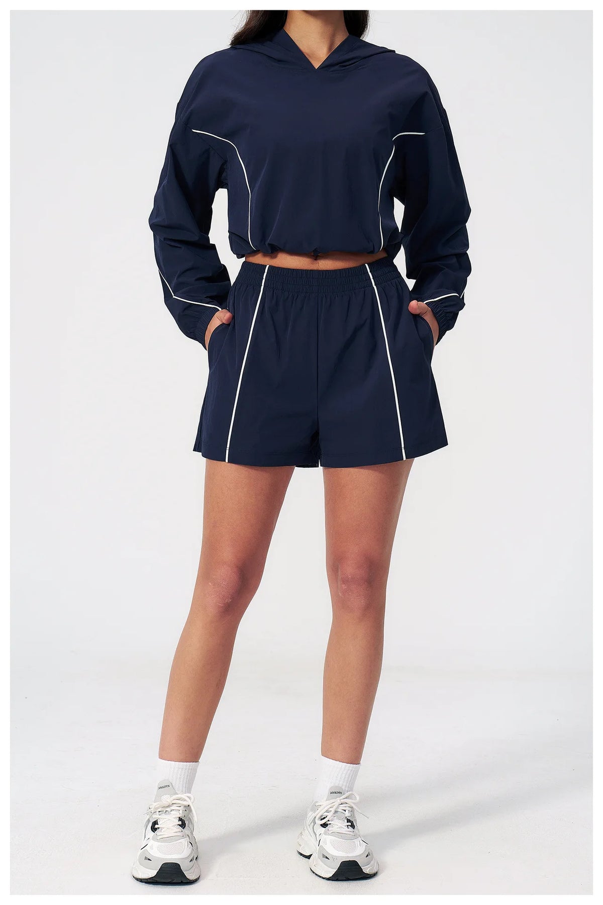 Women’s hooded windbreaker set in navy, front view with cropped jacket and matching shorts