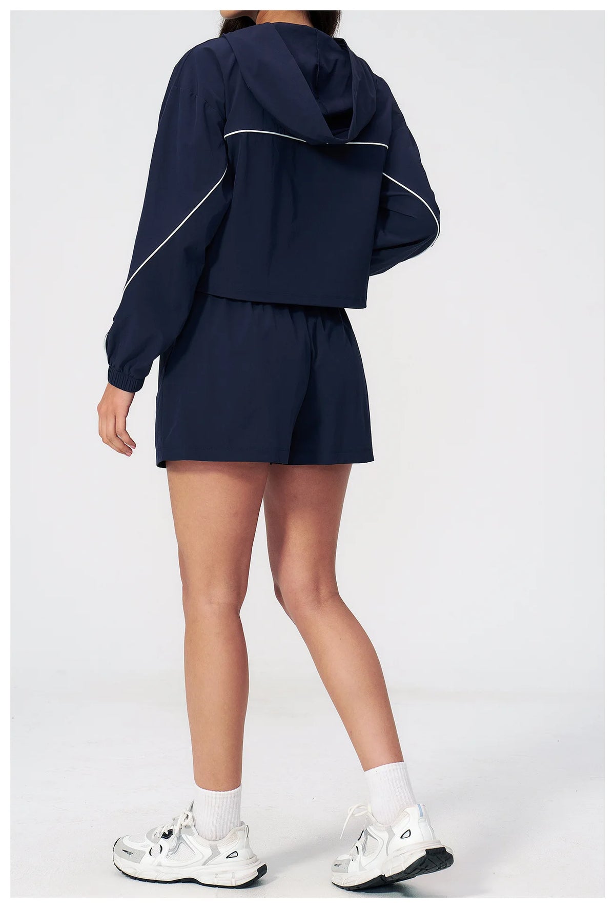 Women’s hooded windbreaker set in navy, back view with hood and matching shorts