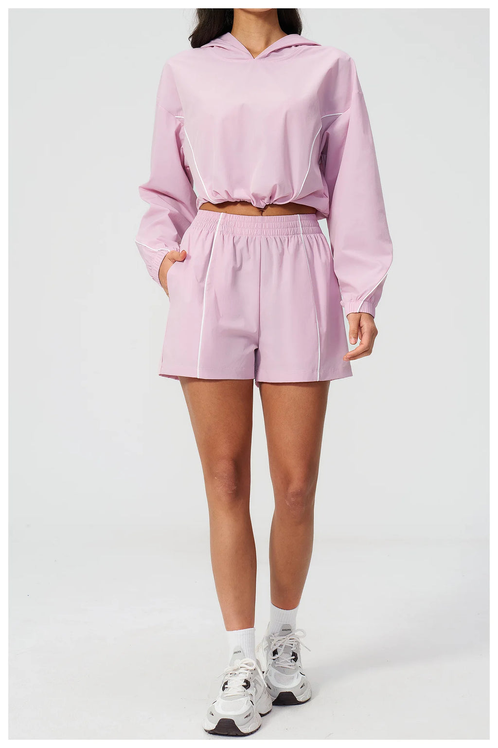 Pink hooded windbreaker top and matching athletic shorts set, front view, elastic waistband