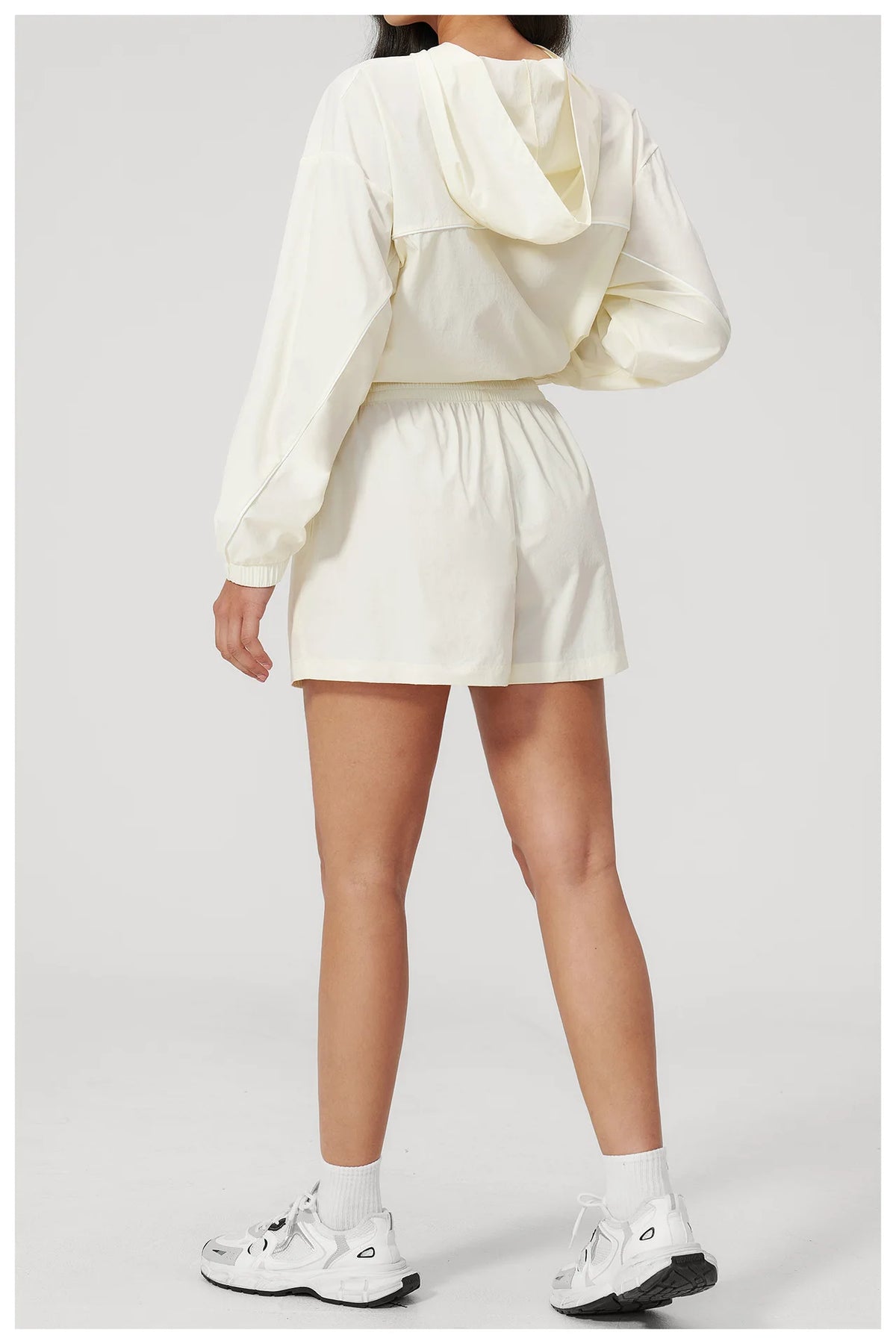Cream hooded windbreaker top and matching shorts set from back, elastic waist