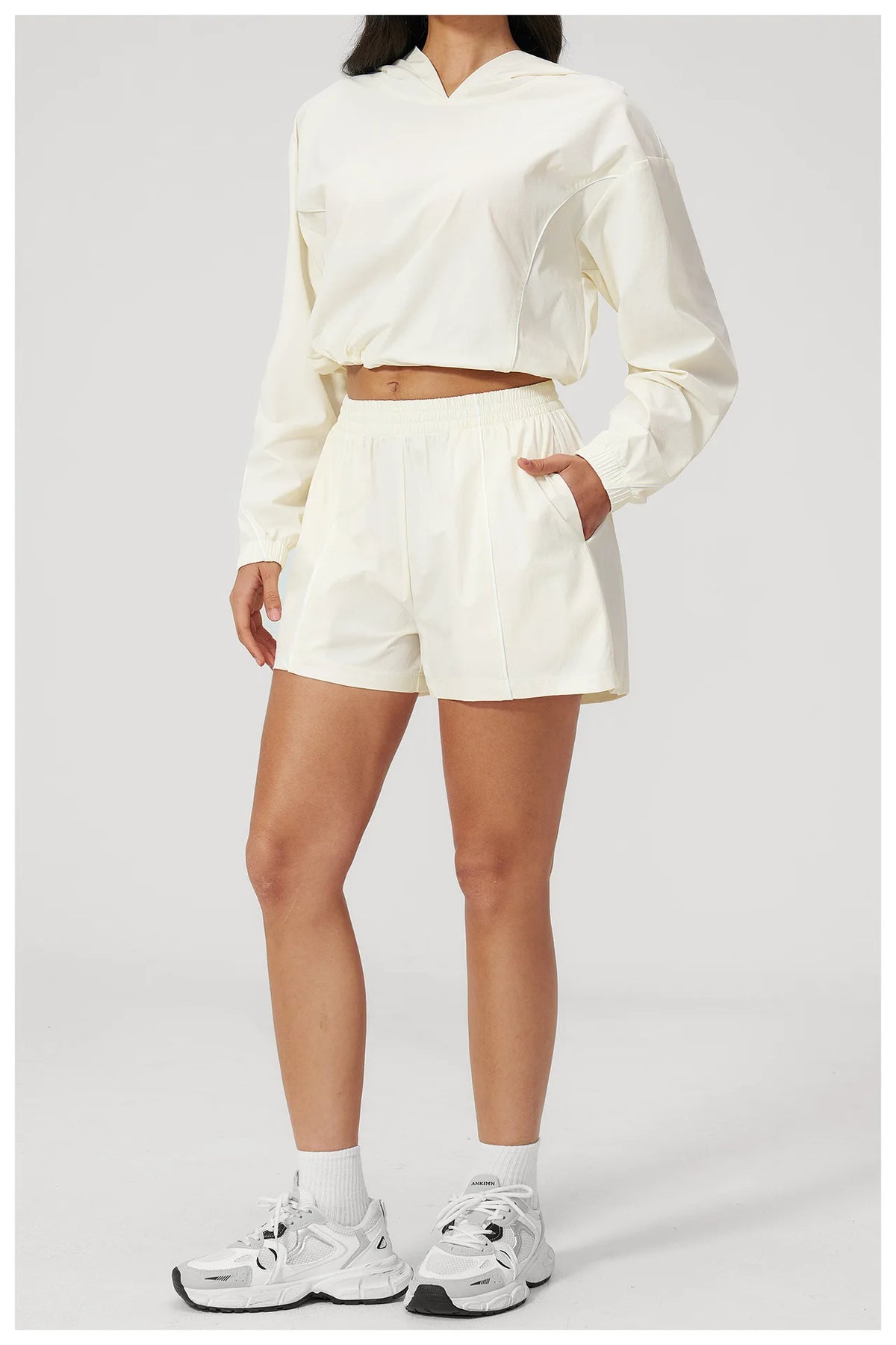 Cream hooded windbreaker top and matching athletic shorts set, long sleeves, elastic waist