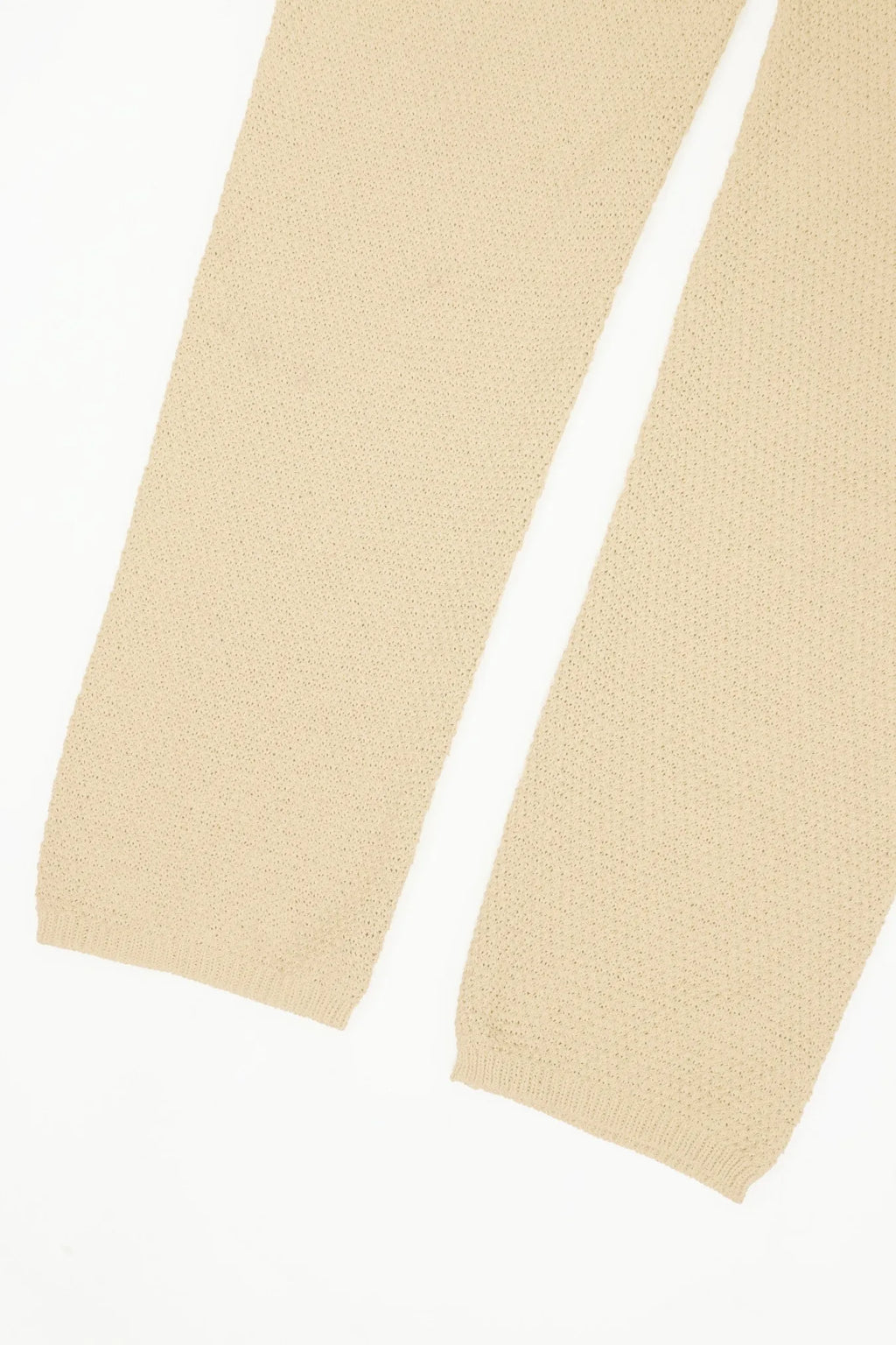 Ivory wide-leg knit romper leg close-up with gathered hem