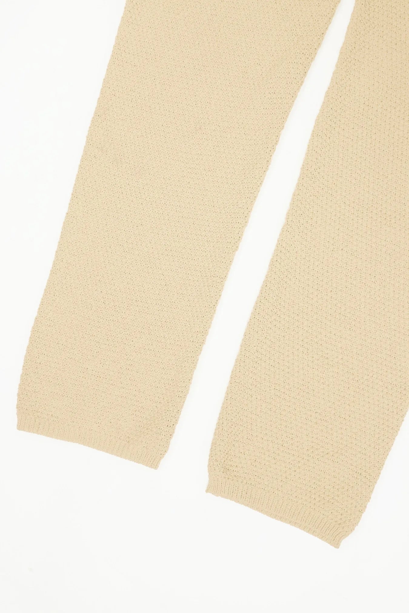 Ivory wide-leg knit romper leg close-up with gathered hem