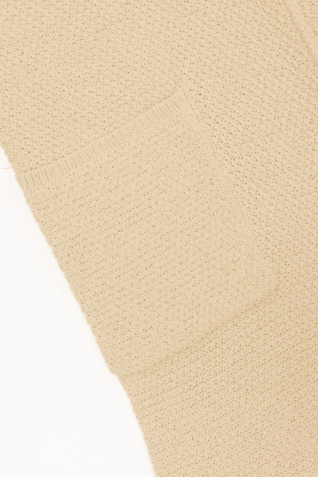 Ivory knit romper fabric close-up, ribbed sleeveless texture