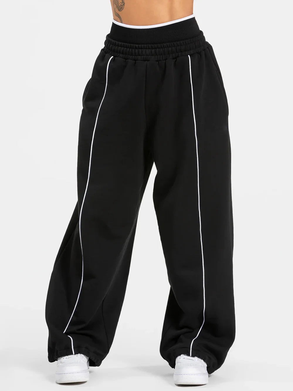 Baggy sweat joggers in black with elastic waistband and white vertical side stripe