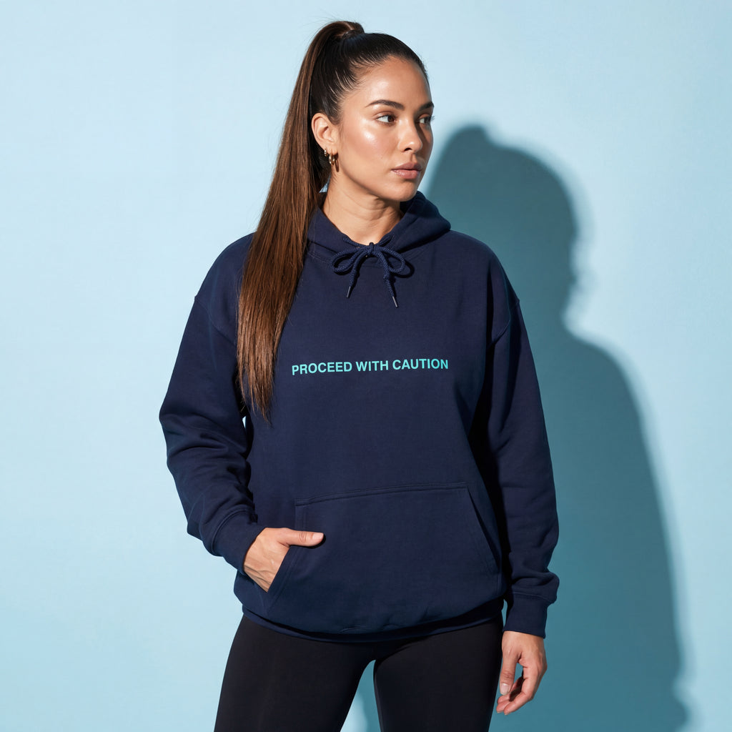 Graphic fleece hoodie, navy blue front with “Proceed With Caution” text and kangaroo pocket