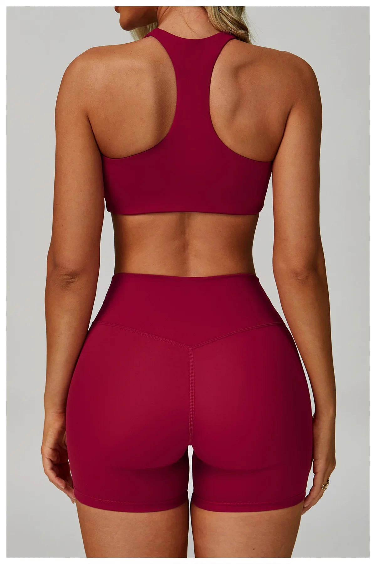 Rose red matching sports bralette and high-waisted active shorts from back