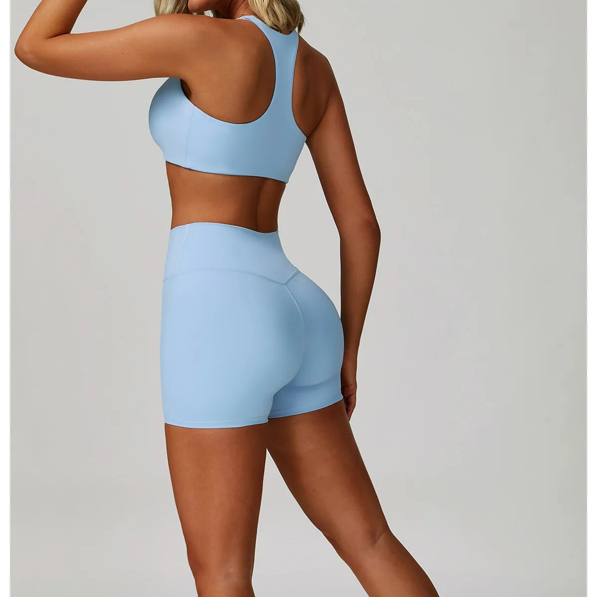 Crystal blue matching sports bralette and high-waisted active shorts from back