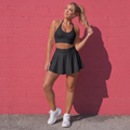 Black sport bra and matching pleated tennis skirt active set with flared skirt hem