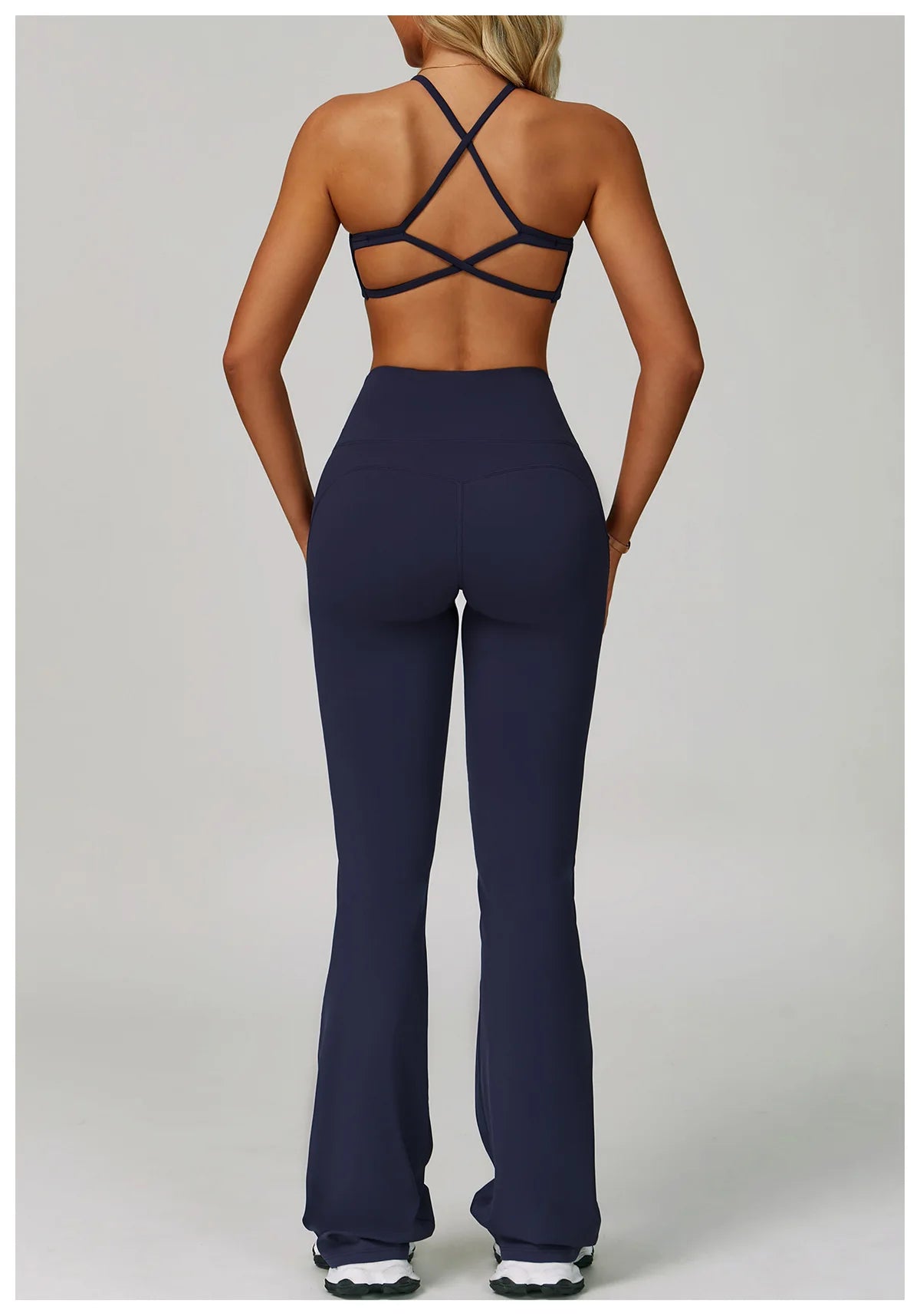 Back view of Xooie Fit criss cross back sports bra and flare pants set in navy color