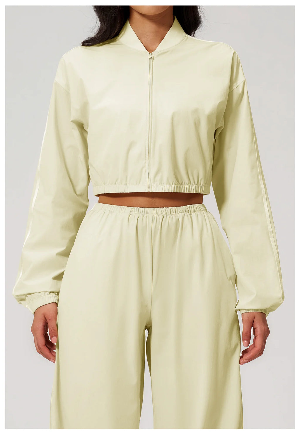 Women’s cropped almond yellow zip-up jacket with long sleeves and elastic hem.