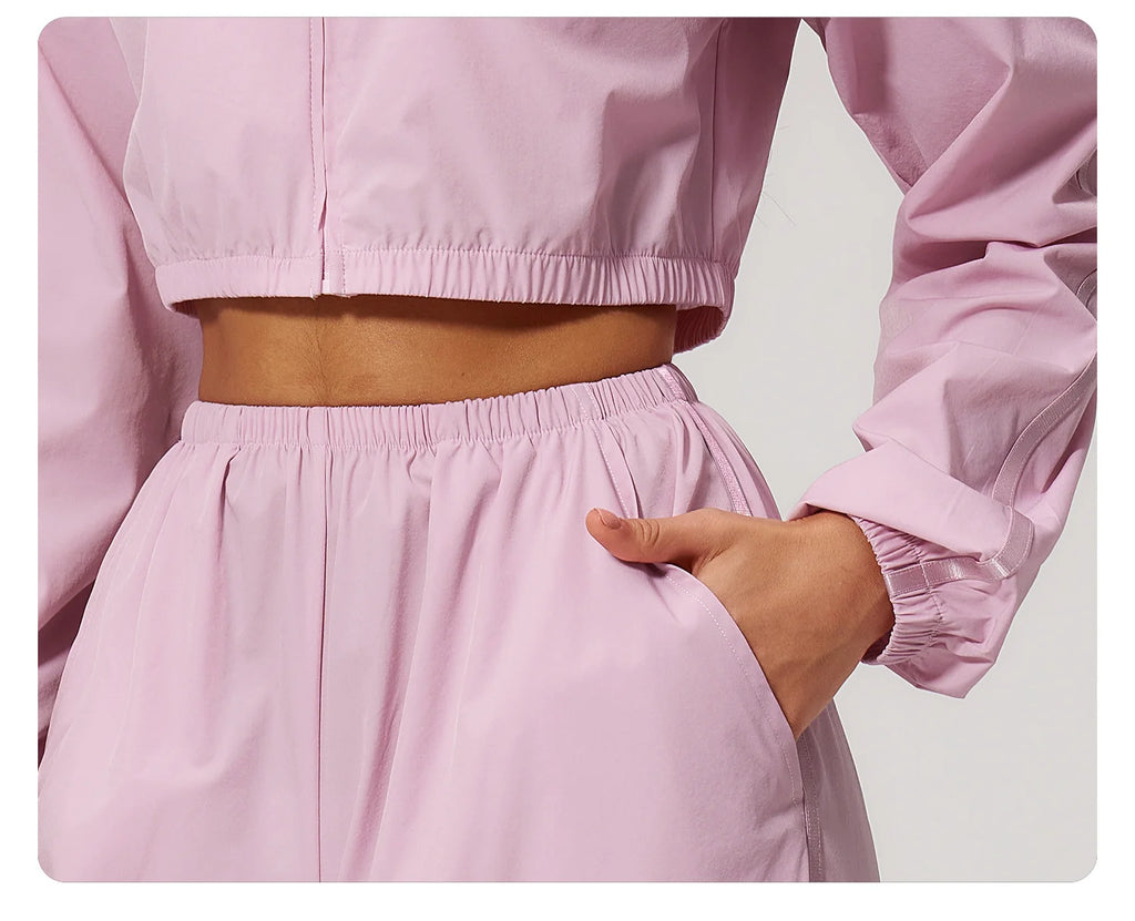Women’s cropped zip-up outdoor jacket in light pink, with elastic hem and cuffs.