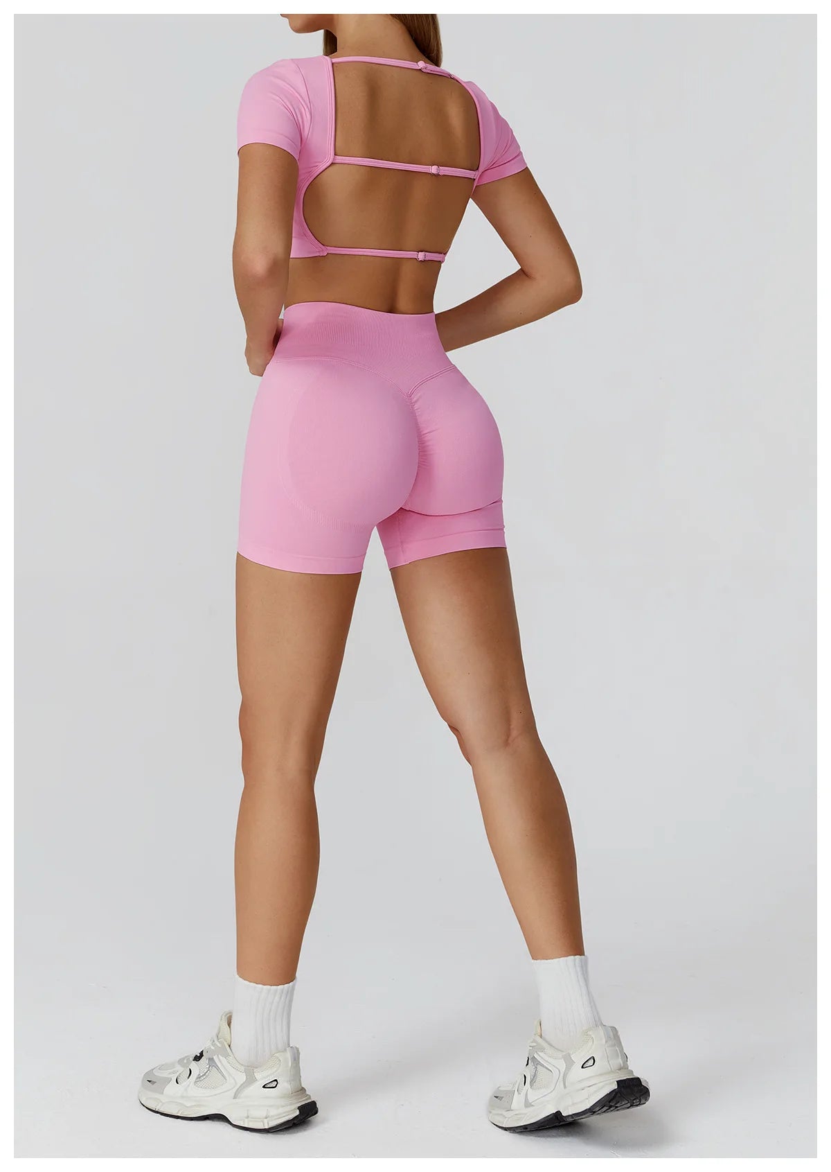 Pink back view: backless crop top with cutout straps and high-waisted shorts