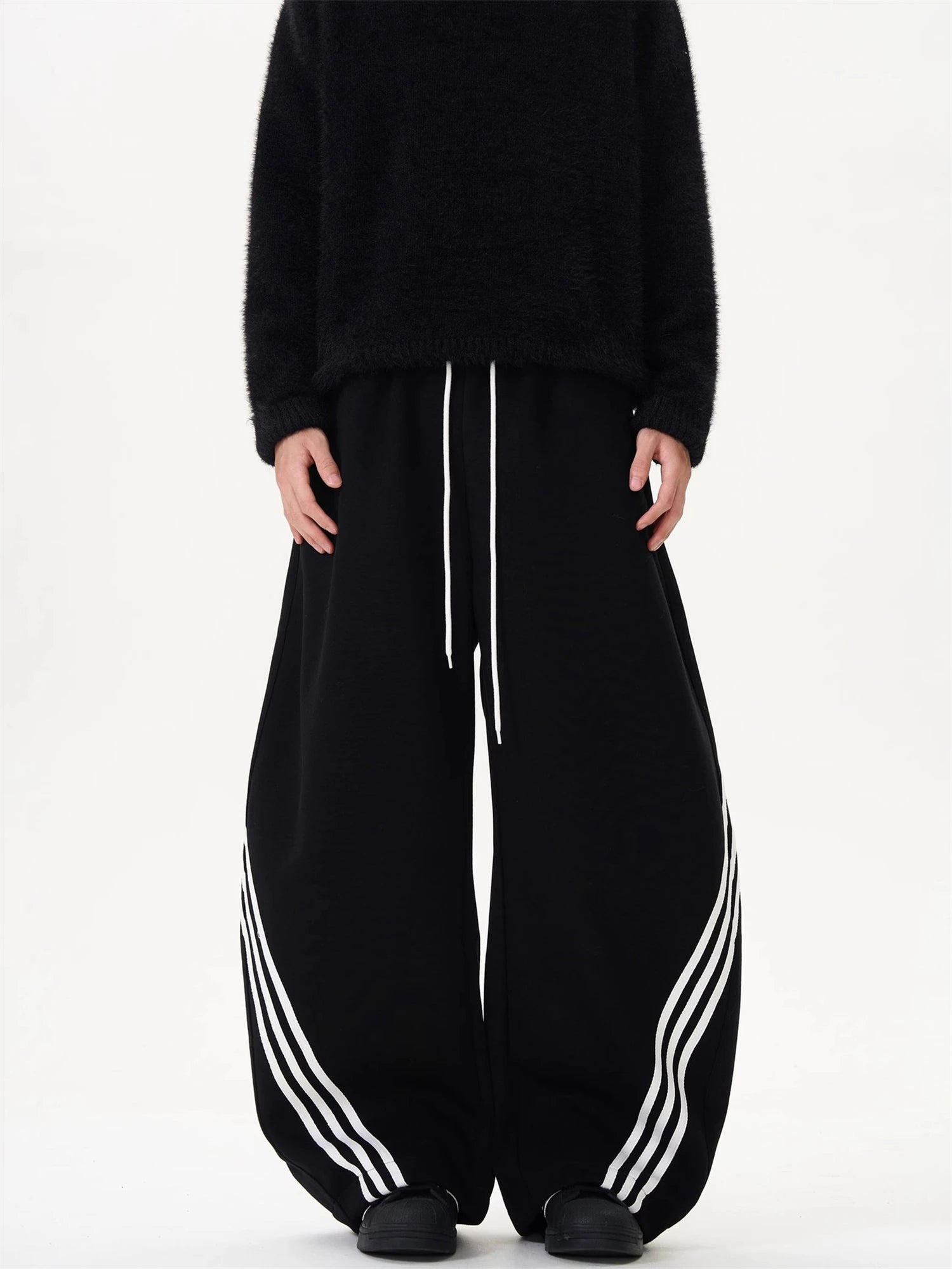 Wide-leg sweatpants in black with white side stripes and center drawstring waist.