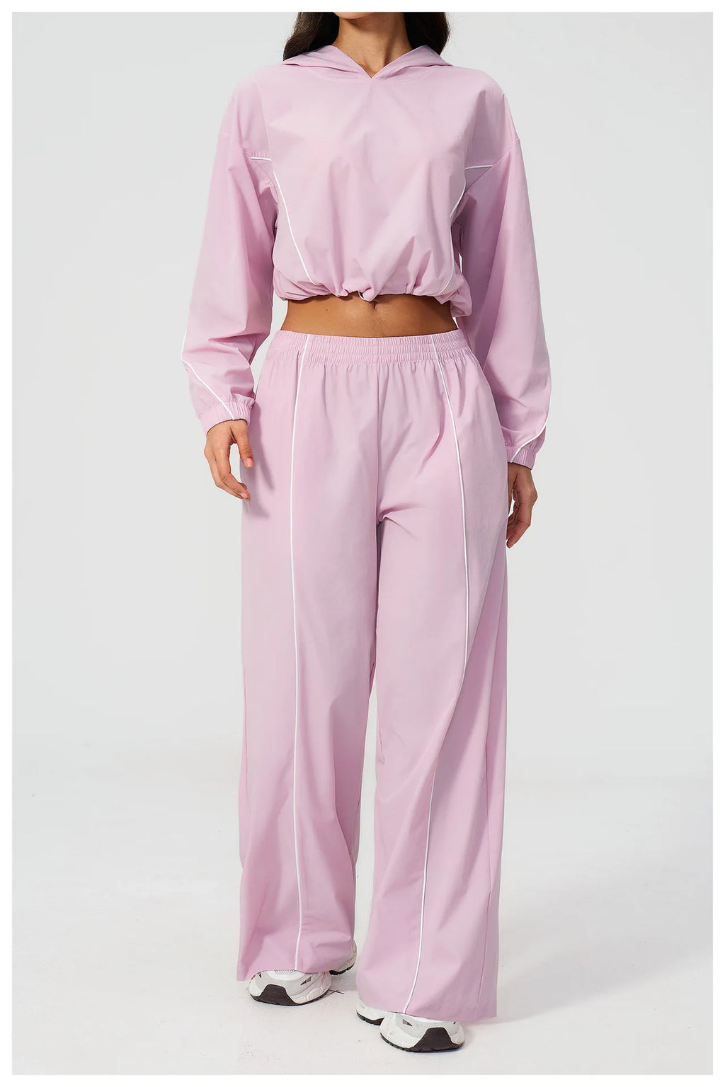 Women’s light pink hooded windbreaker crop top with wide-leg pants, front view