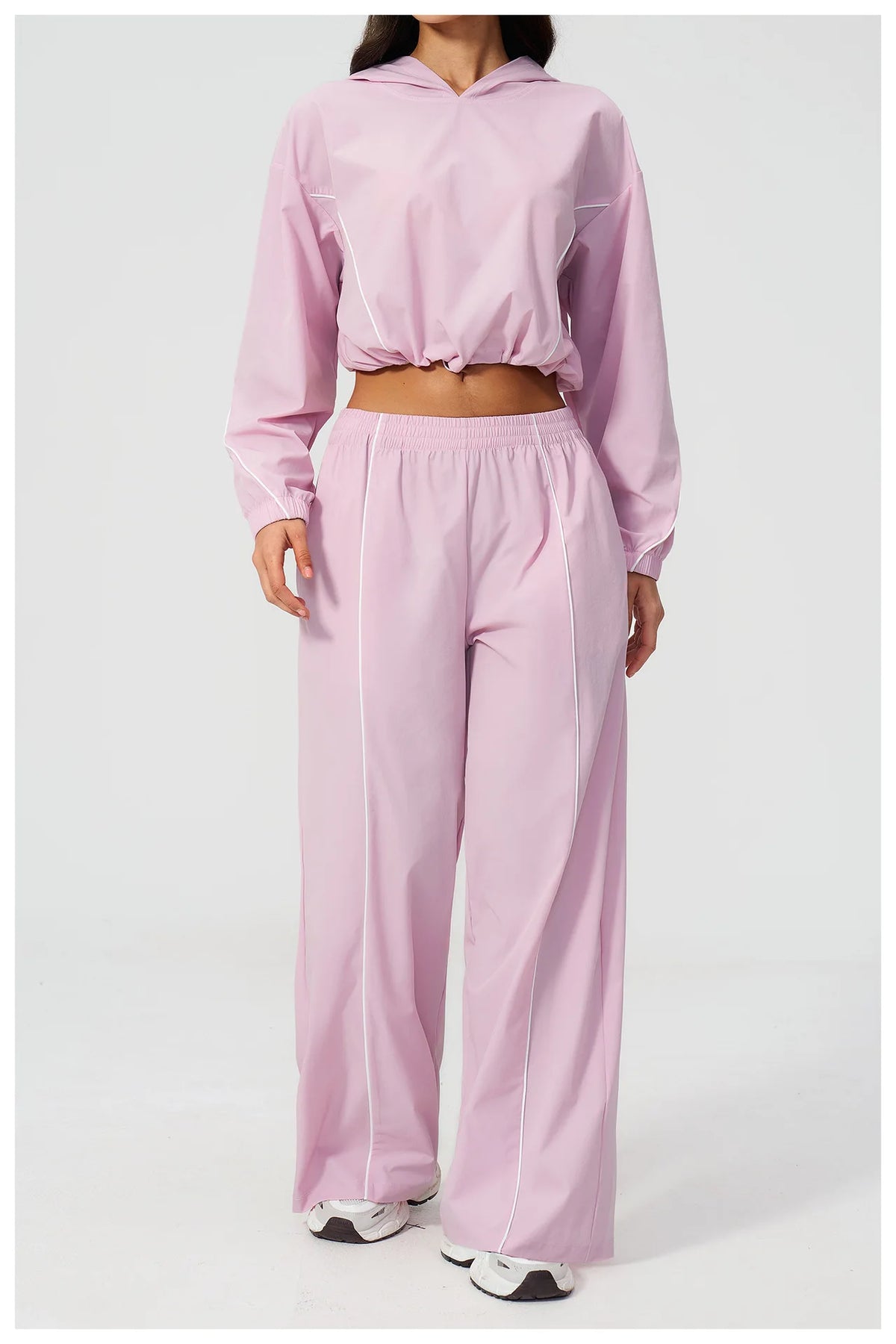 Women’s light pink hooded windbreaker crop top with wide-leg pants, front view