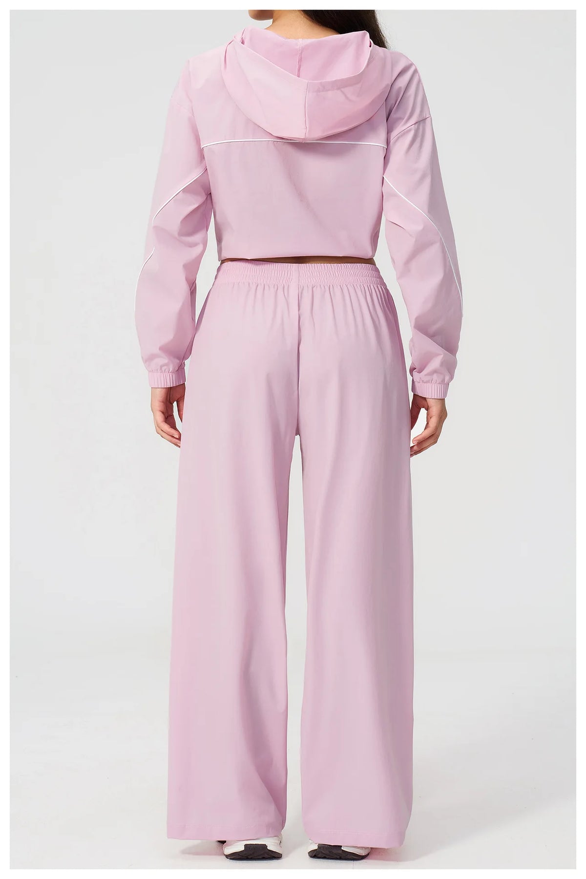 Women’s light pink hooded windbreaker crop top and wide-leg pants set, back view