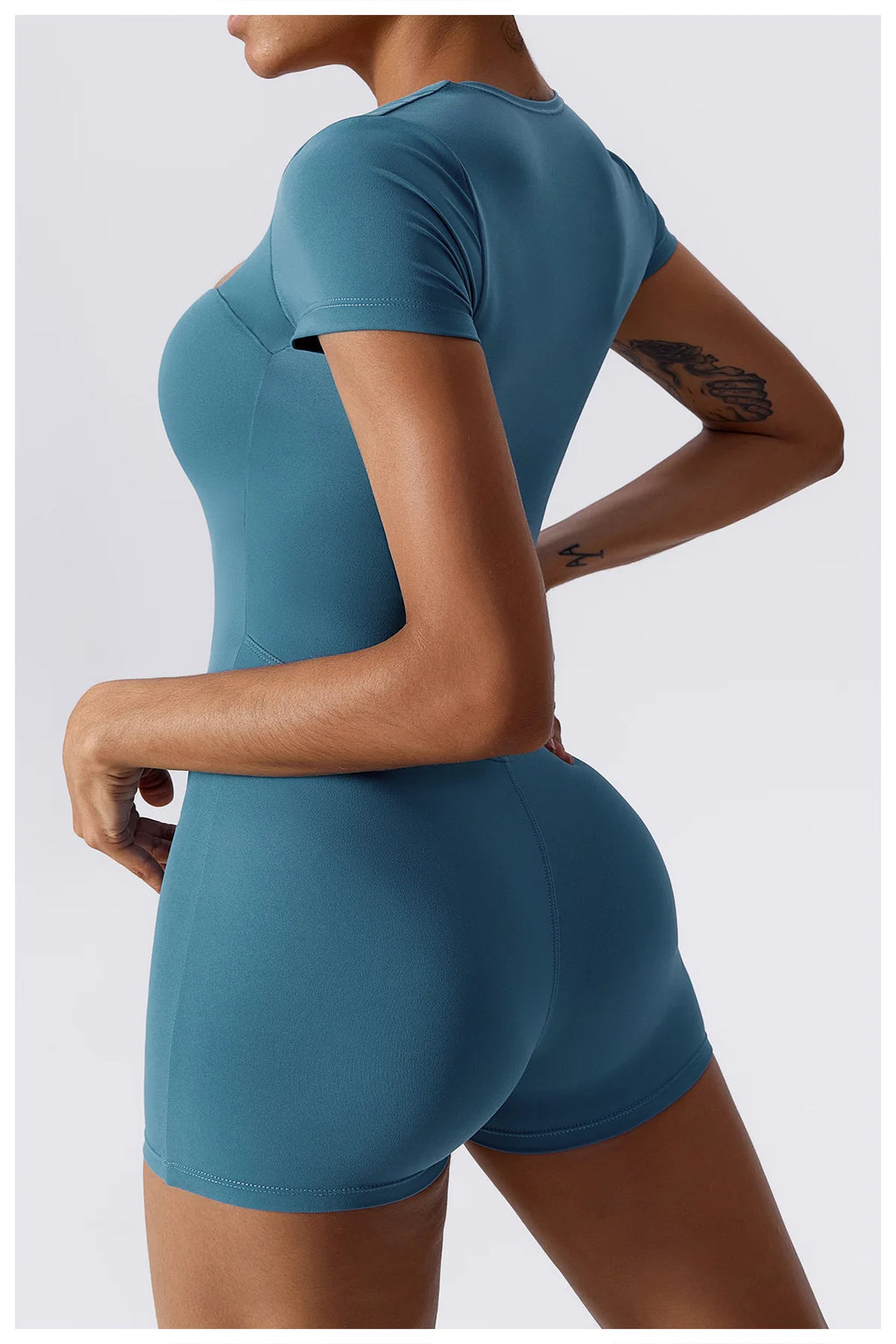Women's teal short one-piece yoga suit, back view with short sleeves