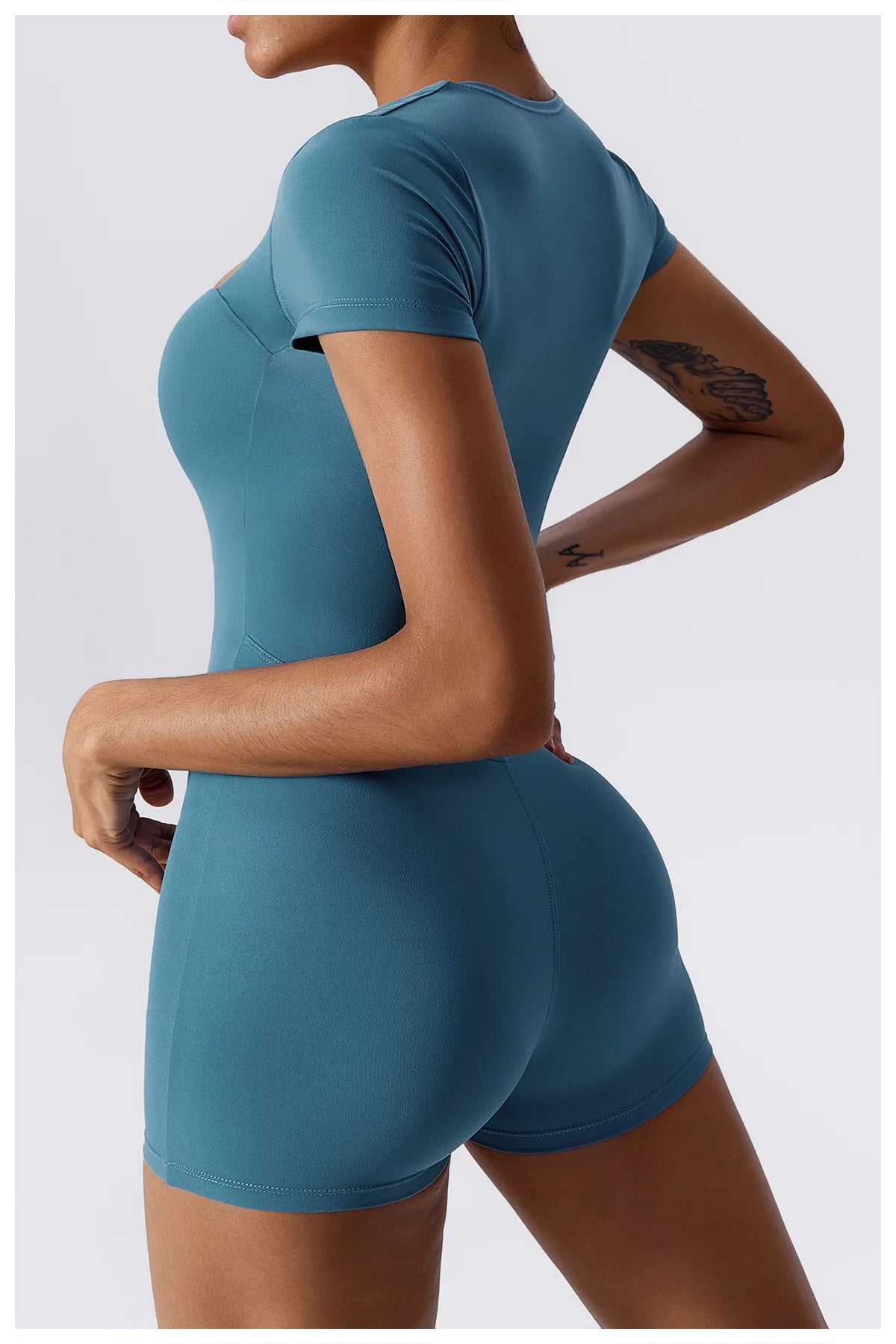 Women's teal short one-piece yoga suit, back view with short sleeves