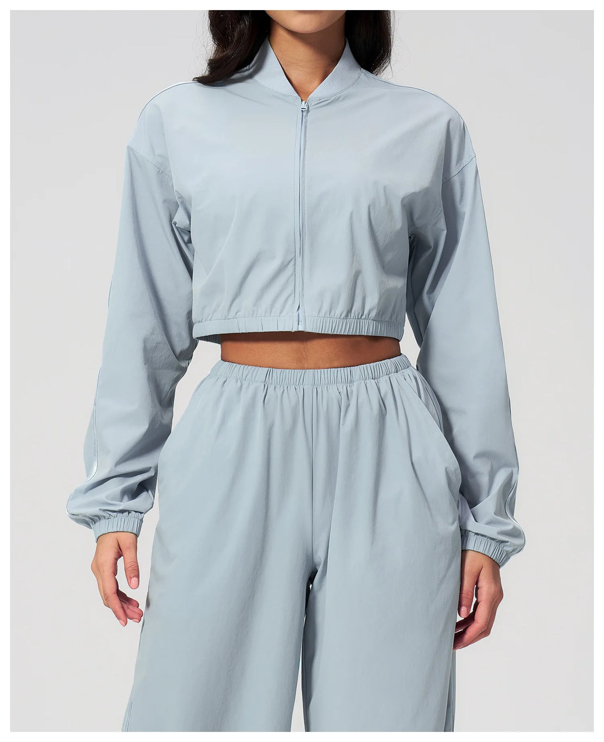 Women’s cropped sky blue zip-up jacket with long sleeves and elastic cuffs.