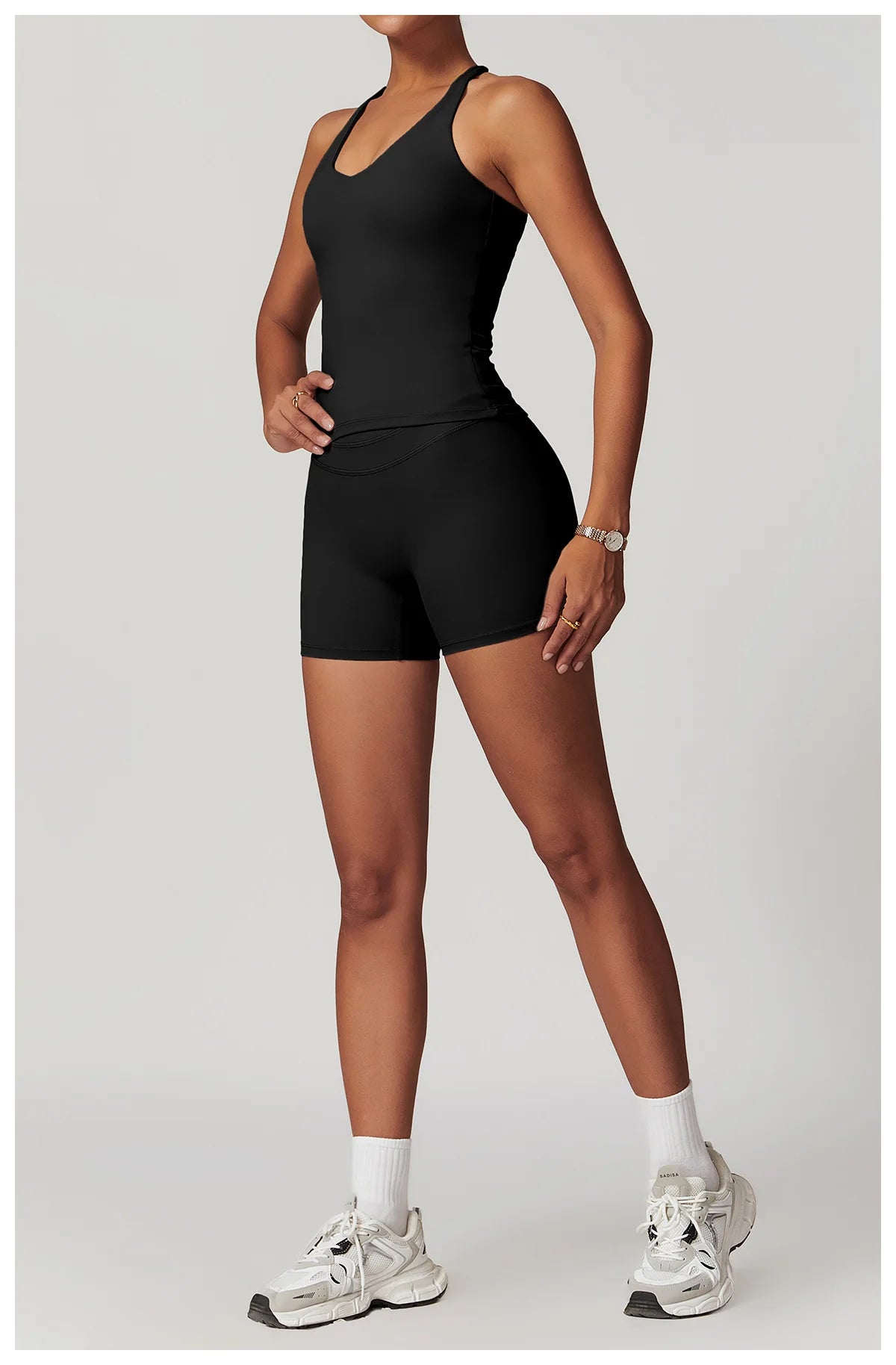 Xooie Fit black fitness tank top and biker shorts set worn by model with white sneakers front