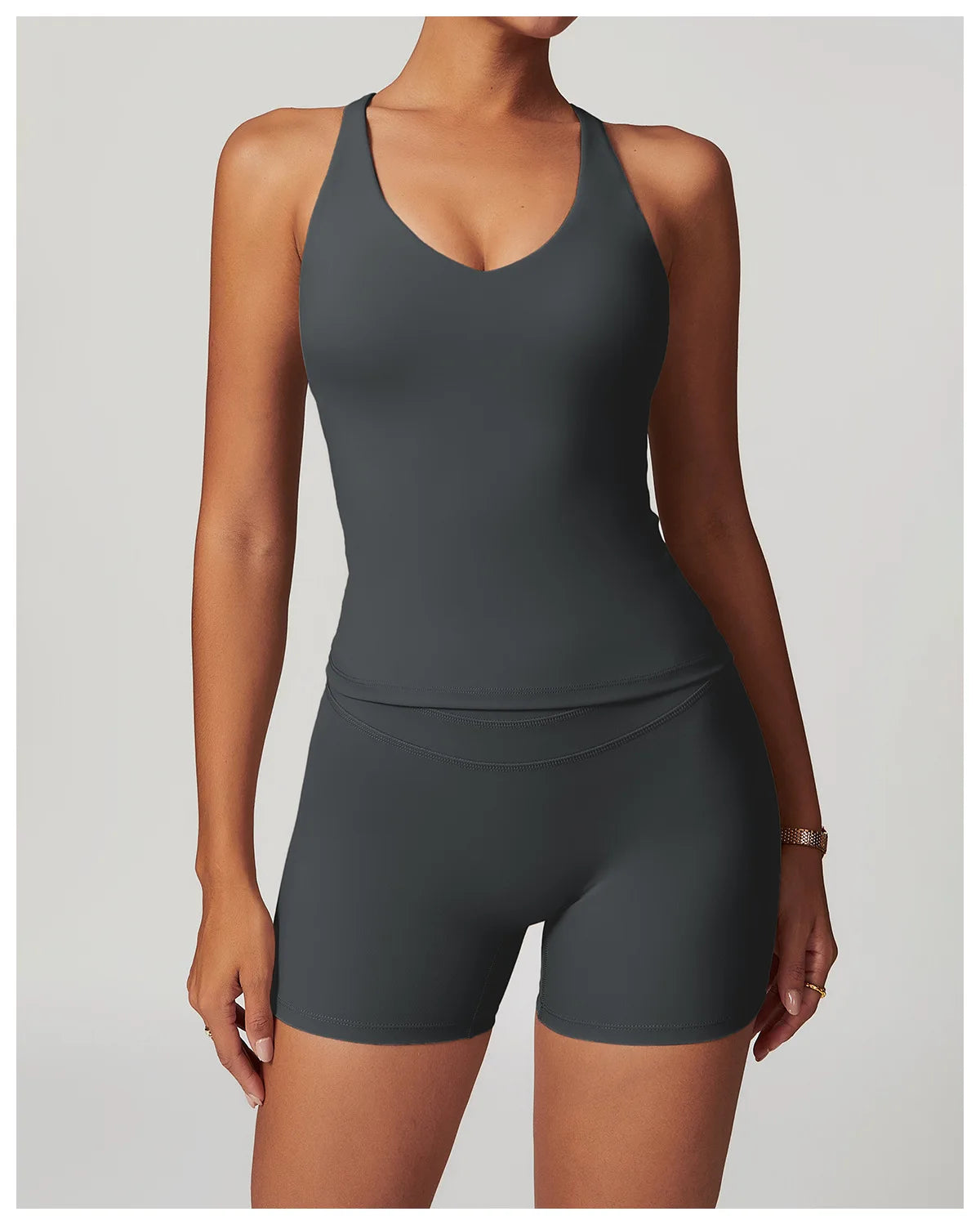 Xooie Fit fitness tank top and biker shorts set in dark gray worn by woman for active workouts