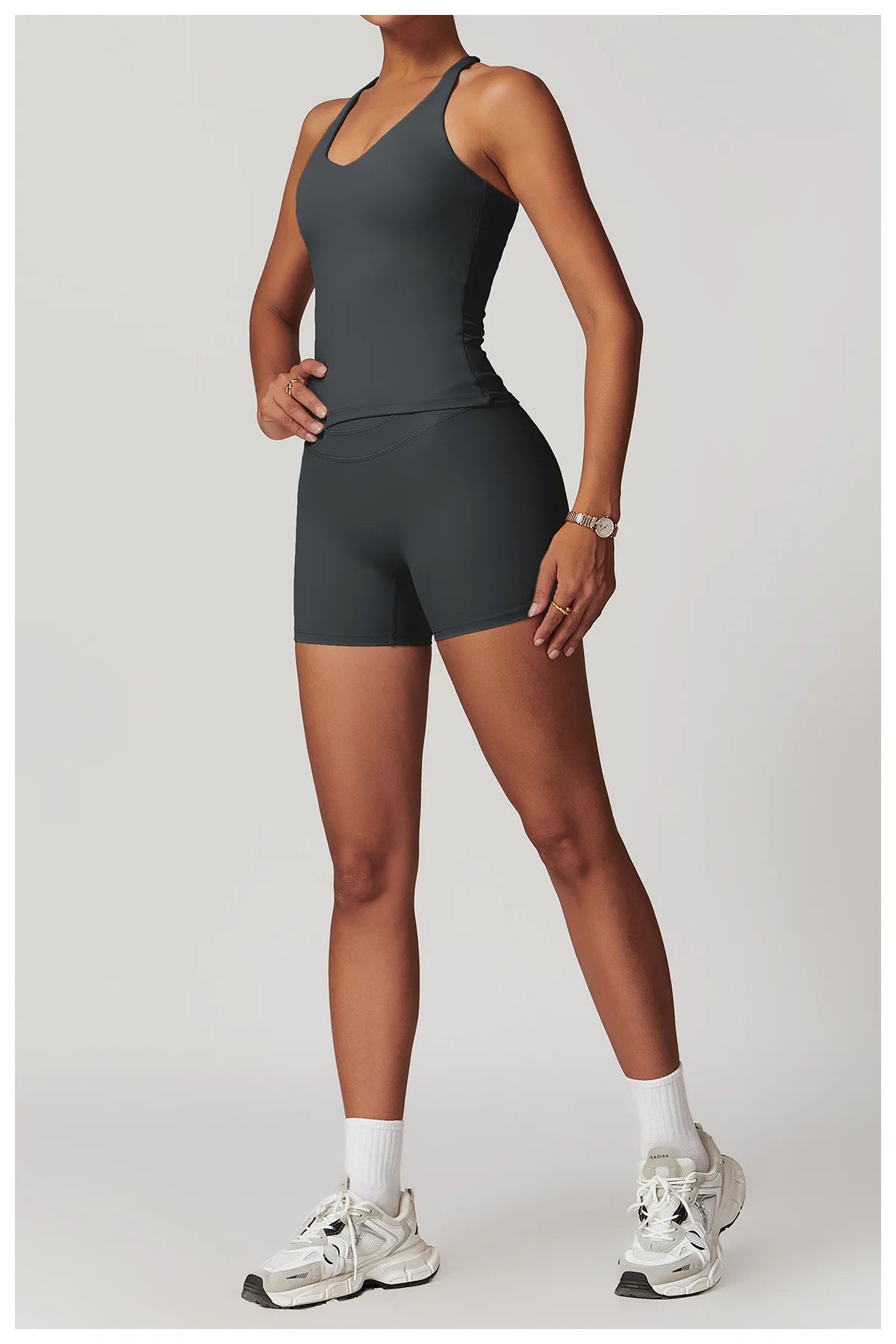 Xooie Fit black fitness tank top and biker shorts set worn by a model with white sneakers
