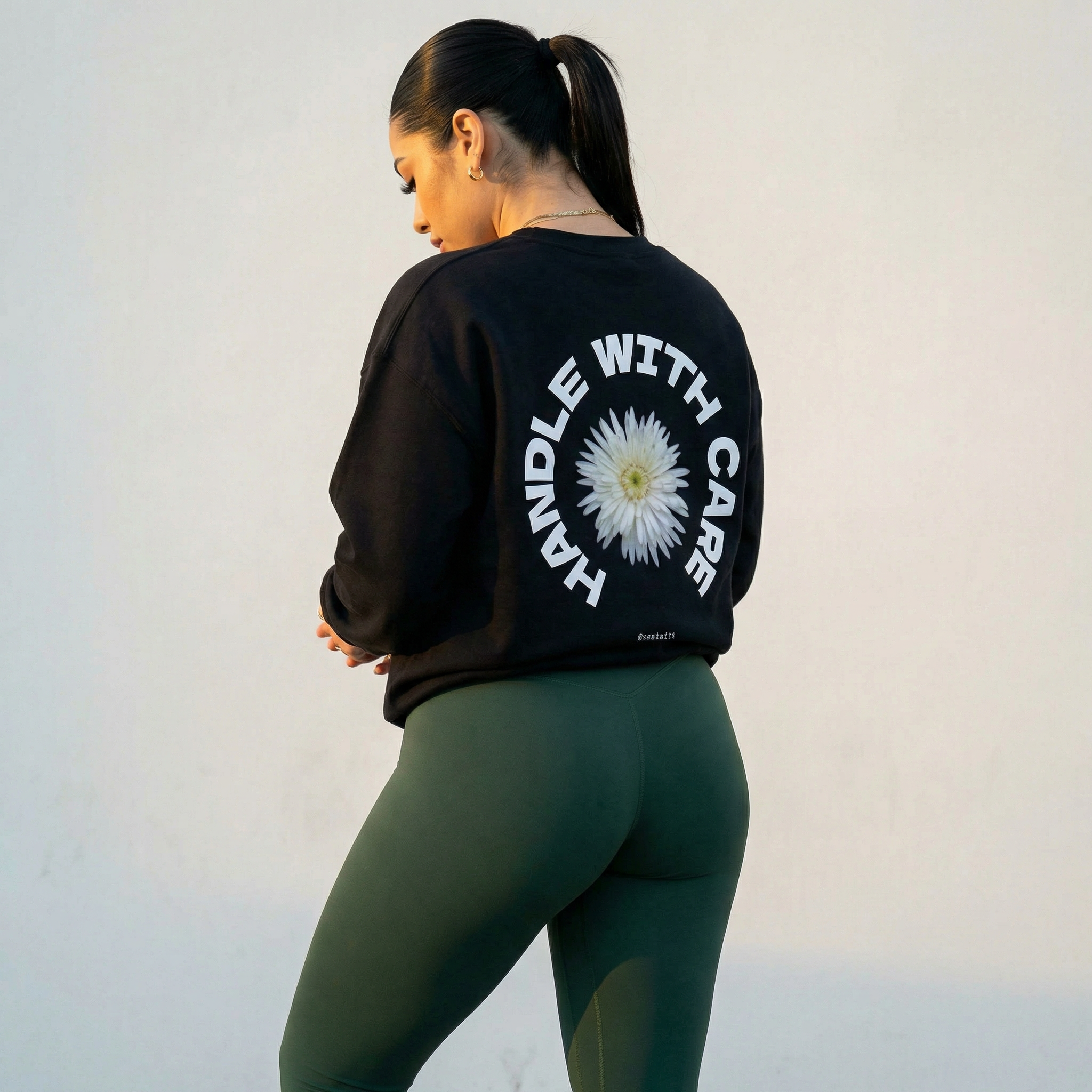 Black crewneck sweatshirt, back graphic with white daisy and circular text