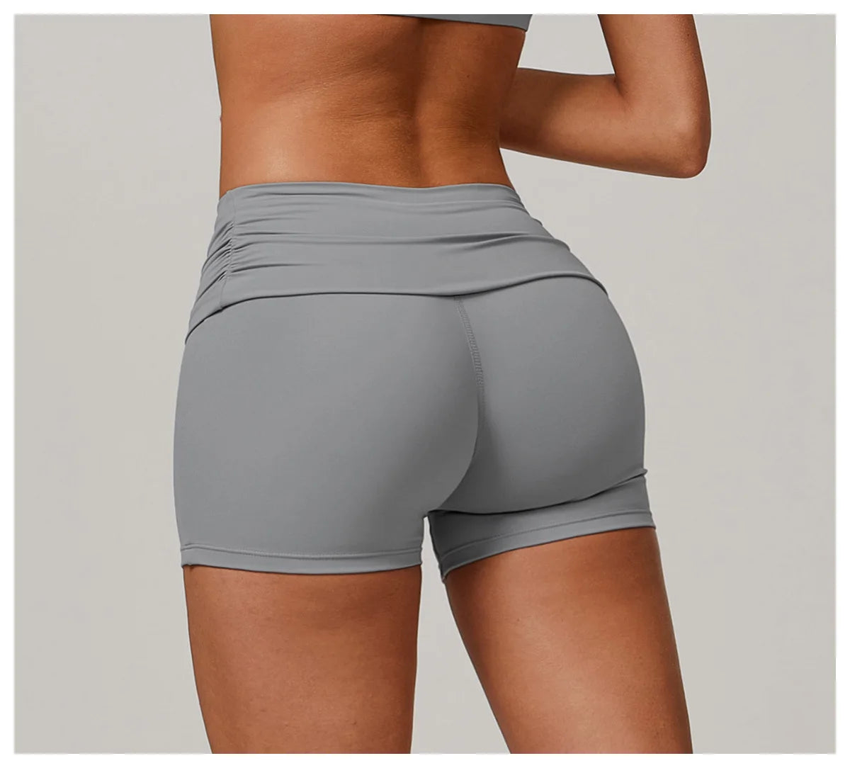 Xooie Fit foldable waistband yoga shorts in gray shown from the back on a model