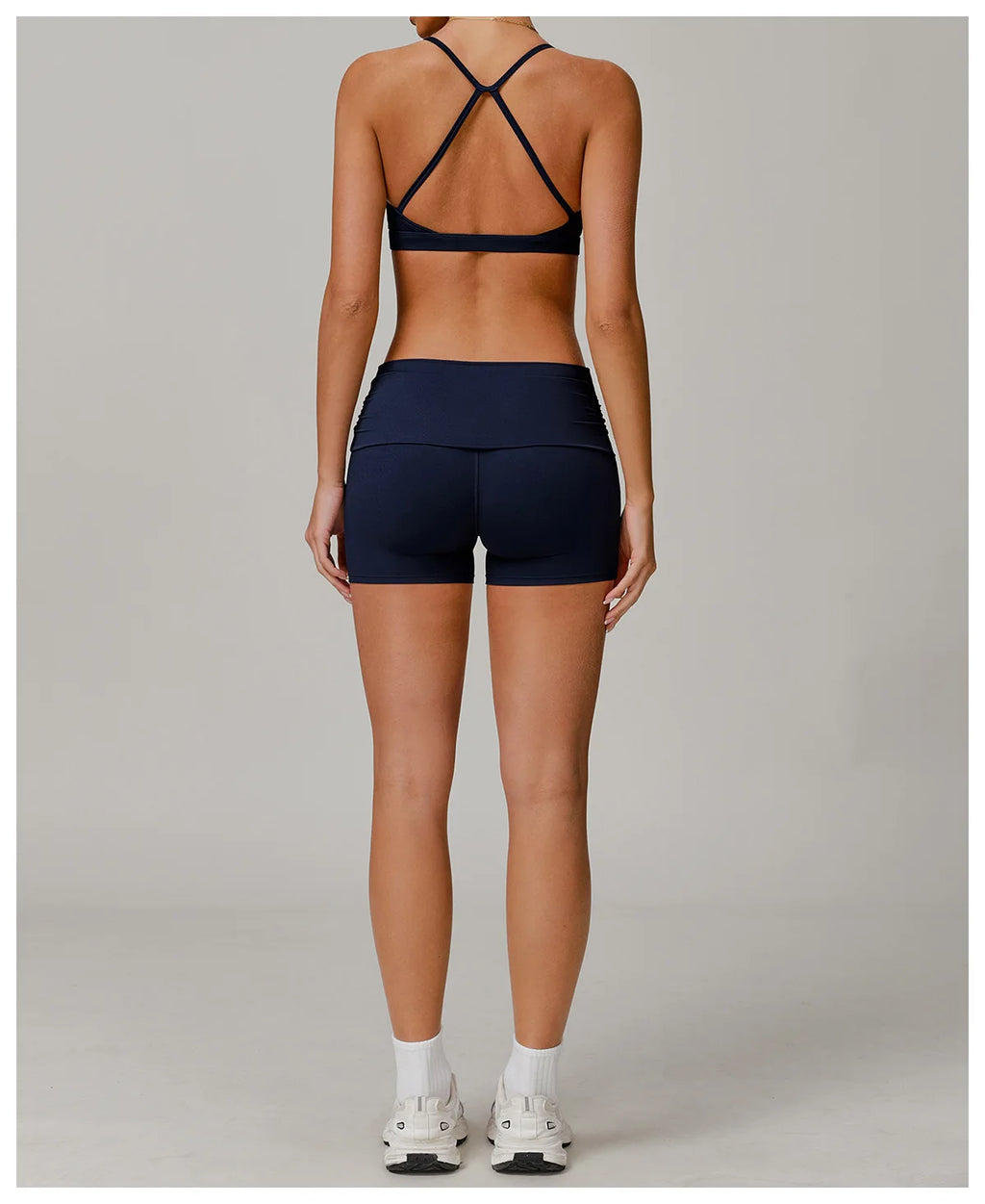 Xooie Fit foldable waistband yoga shorts in black worn by woman shown from back