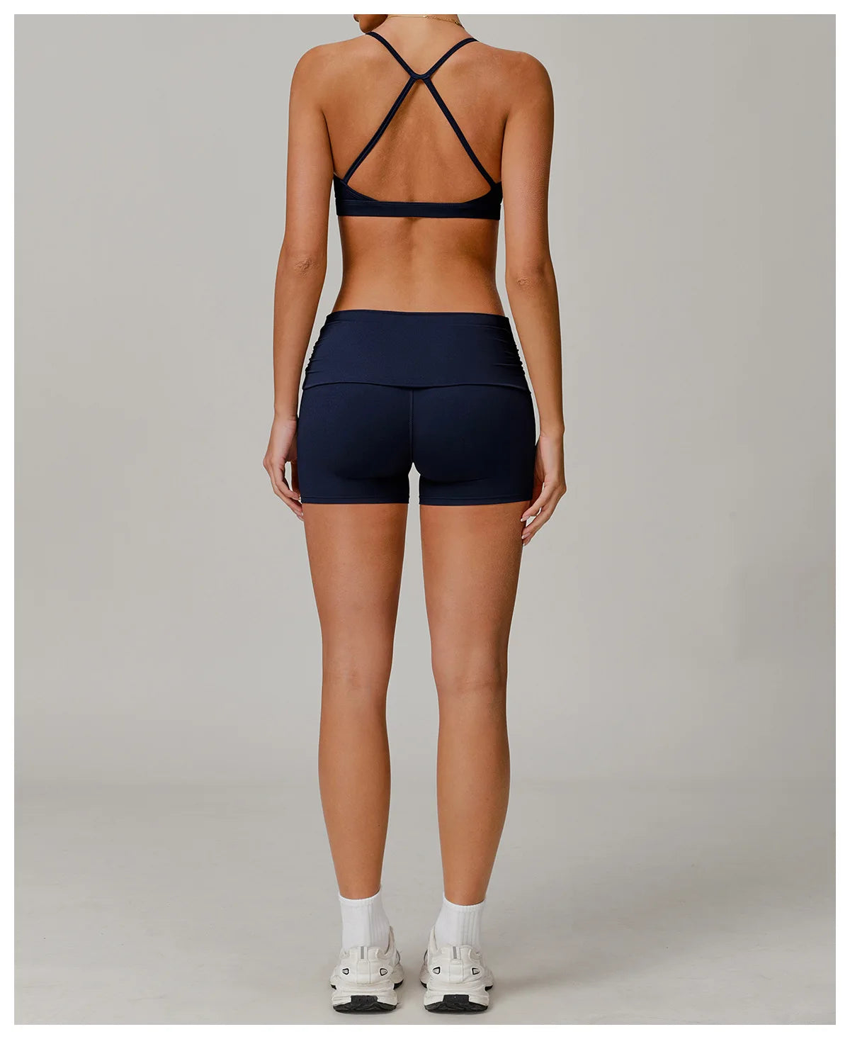Xooie Fit foldable waistband yoga shorts in black worn by woman shown from back