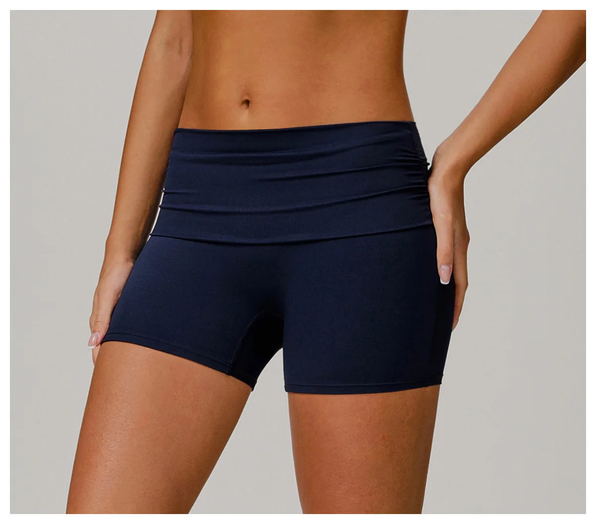 Xooie Fit foldable waistband yoga shorts in black worn on female model showing mid-rise fit