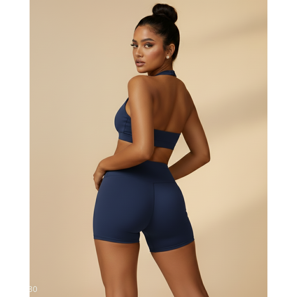 Woman wearing a blue sports bra and shorts set on a beige background