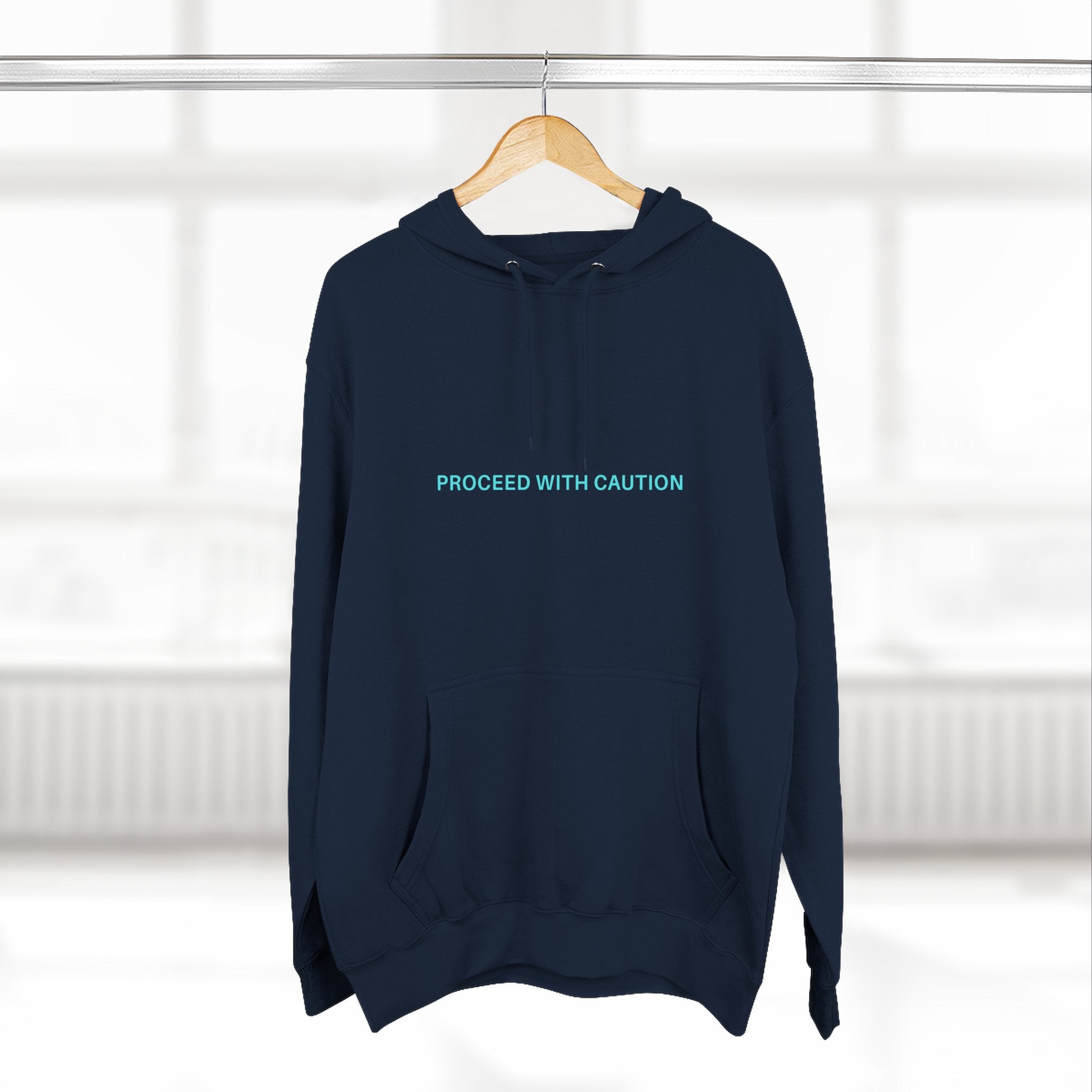 Navy blue fleece hoodie with hood and kangaroo pocket, chest “PROCEED WITH CAUTION”