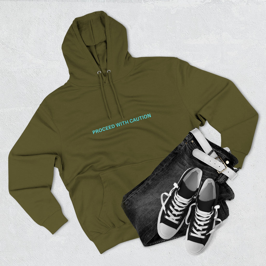 Army green hoodie with front chest text “PROCEED WITH CAUTION”
