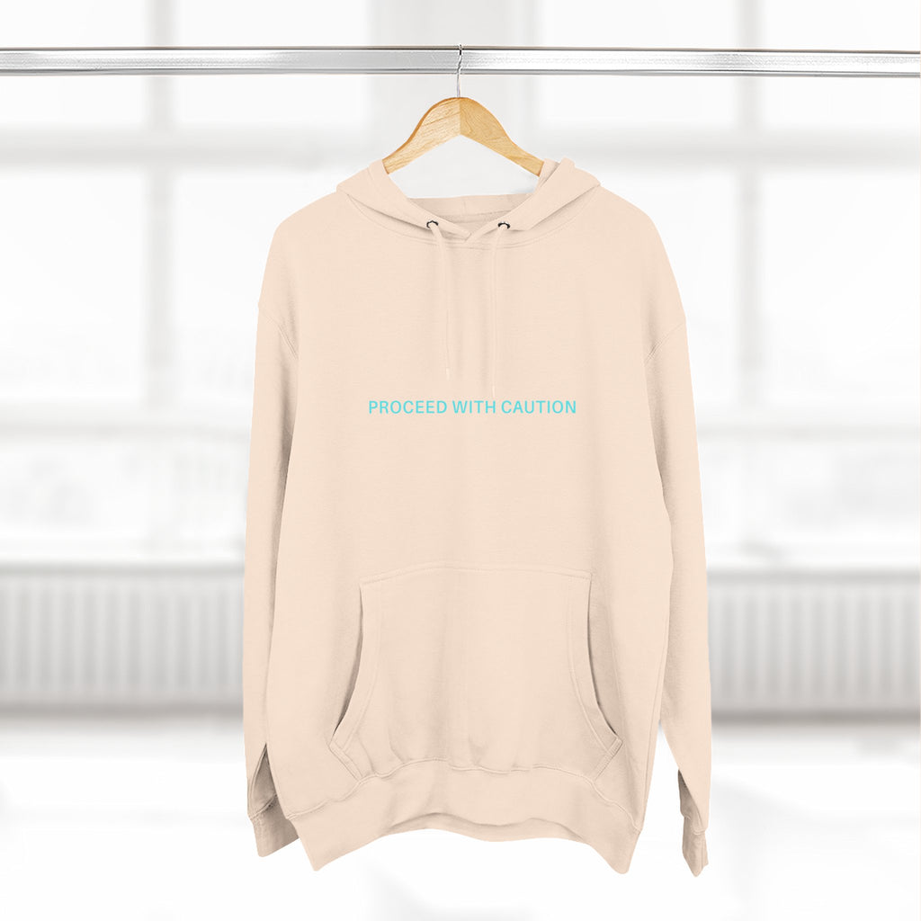 Off-white fleece hoodie with hood and kangaroo pocket, chest “PROCEED WITH CAUTION”